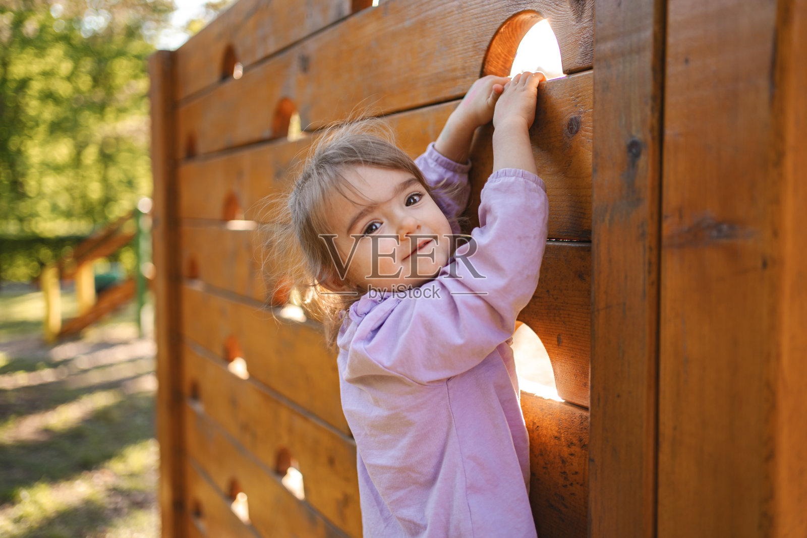 可爱的小女孩正在操场上爬照片摄影图片