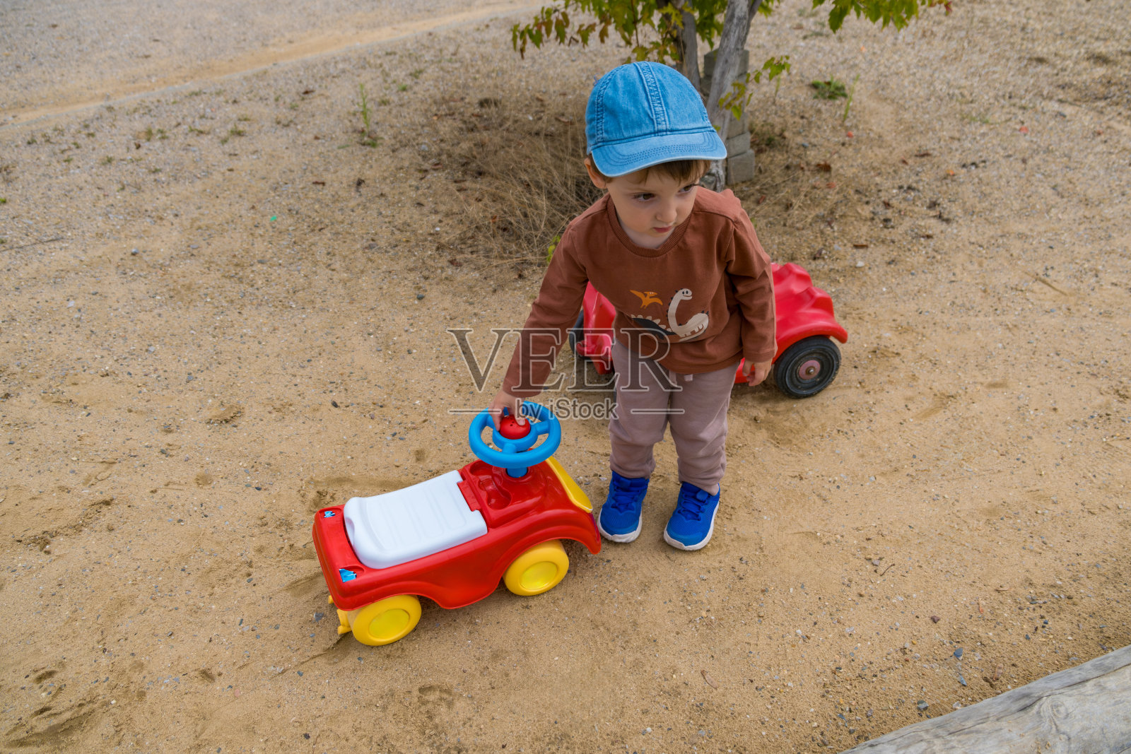 一个男孩正在砾石操场上玩耍。男孩正在玩许多小石头照片摄影图片