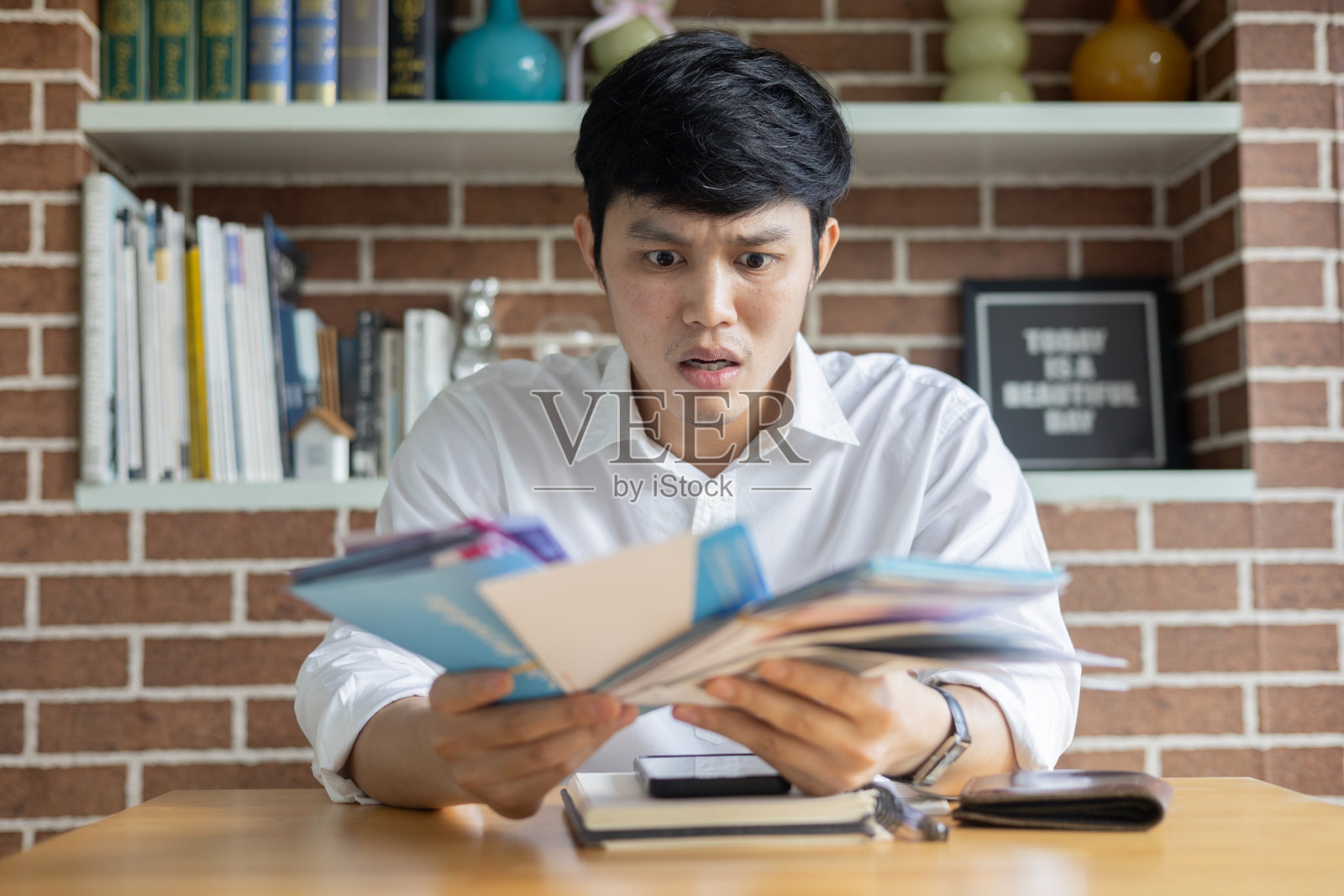 近距离的亚洲年轻人拿着银行或金融机构的发票信，对新一代人们的生活方式观念感到震惊，并在客厅检查费用照片摄影图片