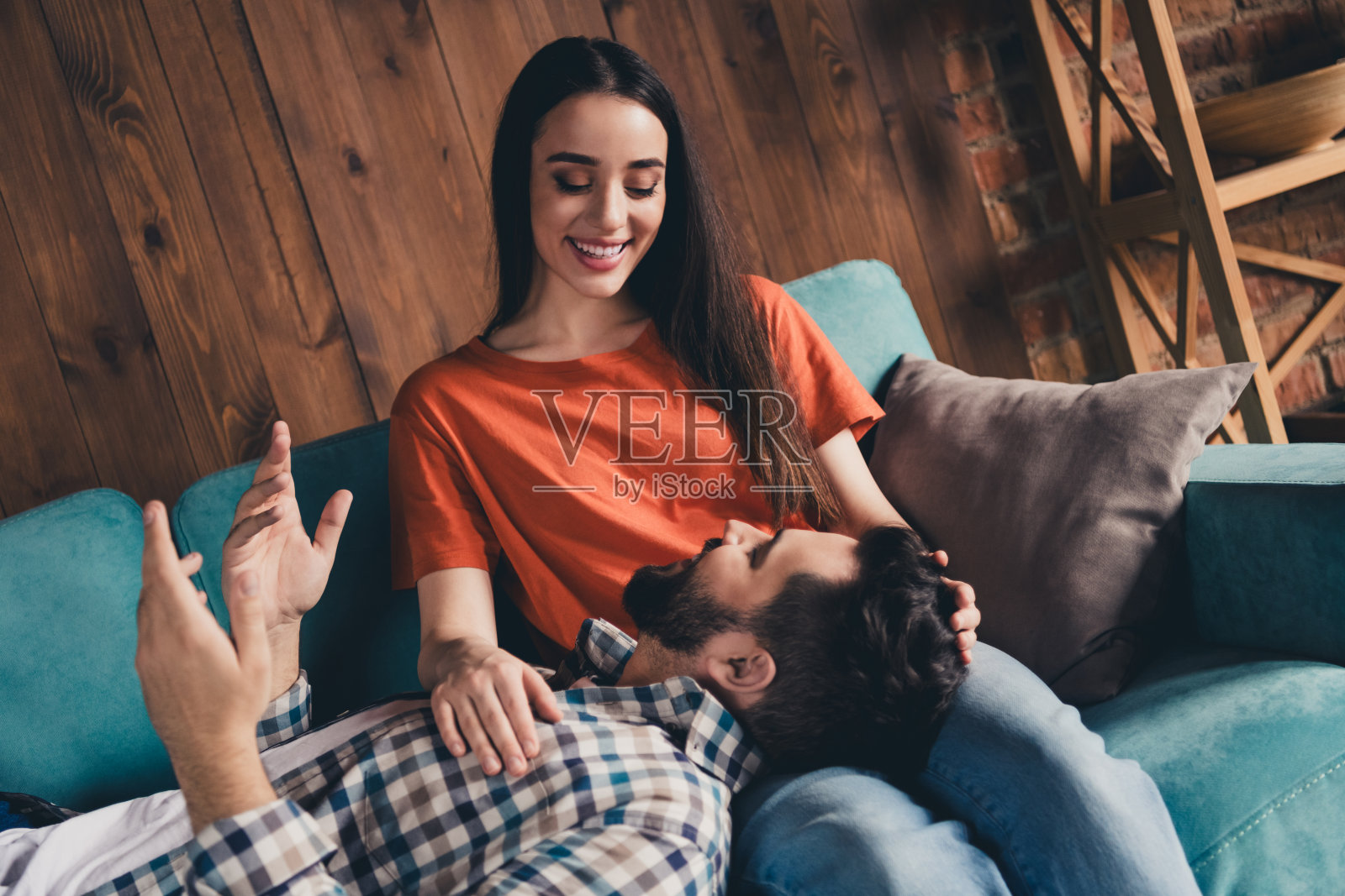 欢快可爱的年轻夫妇的照片躺在沙发上聊天享受周末玩得开心买新公寓在室内在家里照片摄影图片