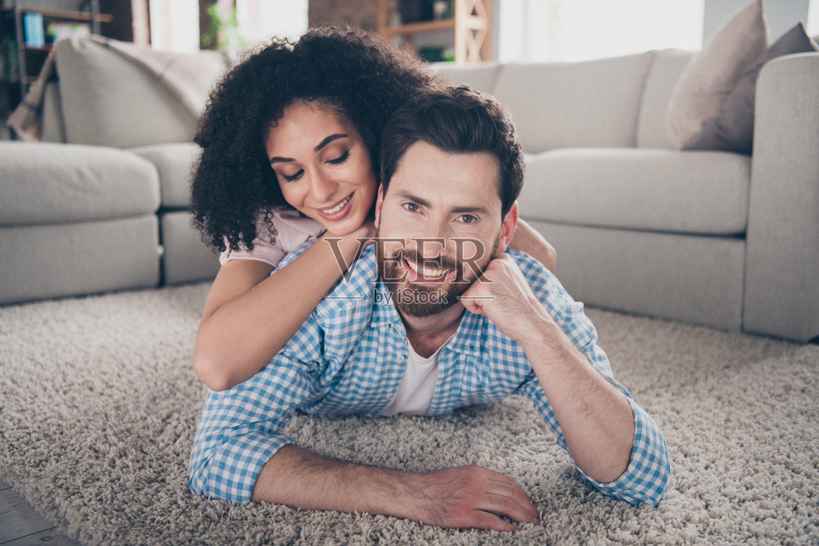 两个年轻漂亮的伙伴的肖像拥抱铺地板现代室内客厅在室内照片摄影图片