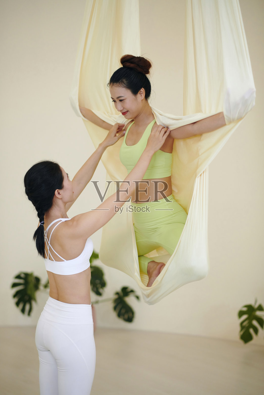 练习空中瑜伽与援助的平衡和稳定照片摄影图片