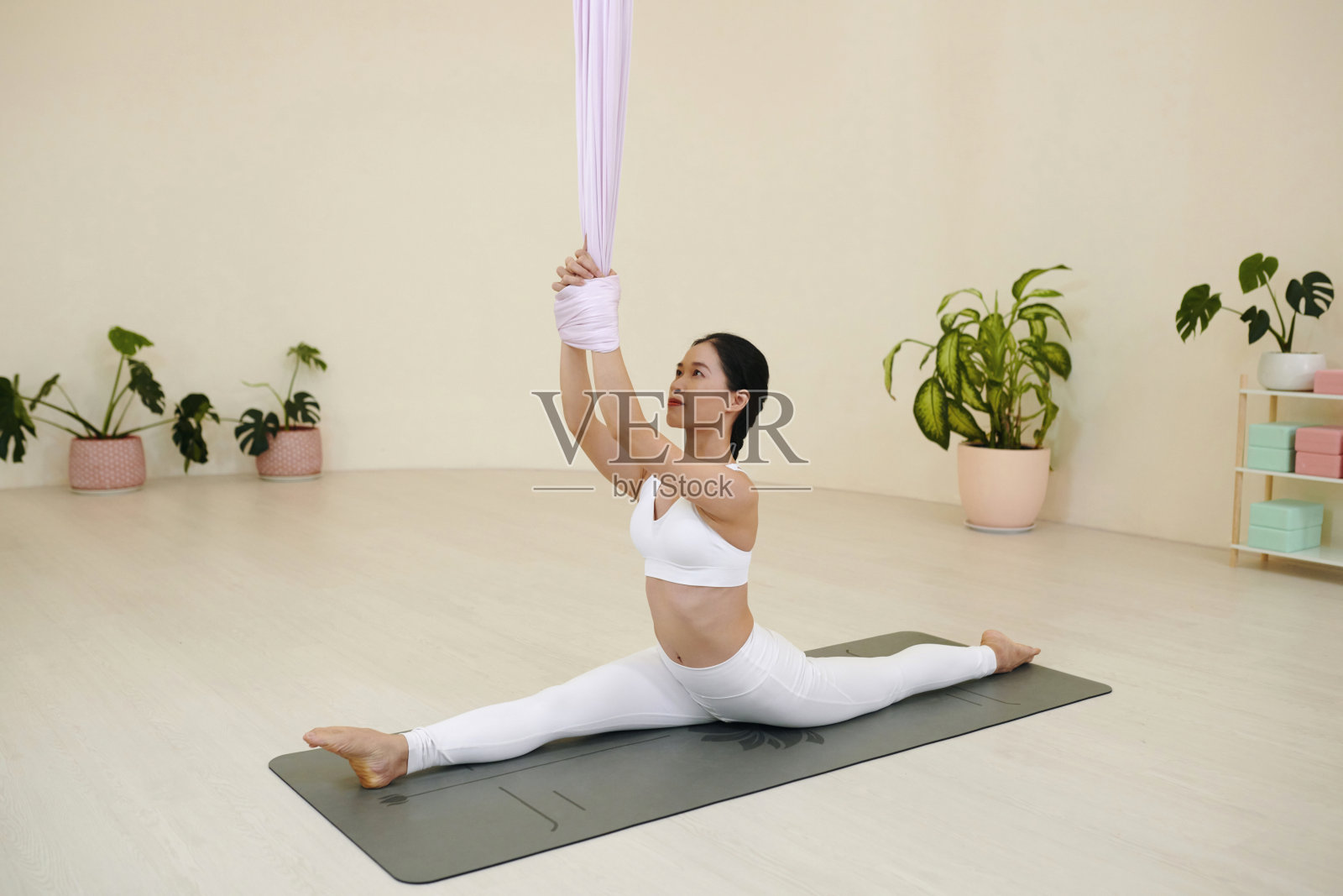 练习空中瑜伽在极简主义的工作室设置照片摄影图片