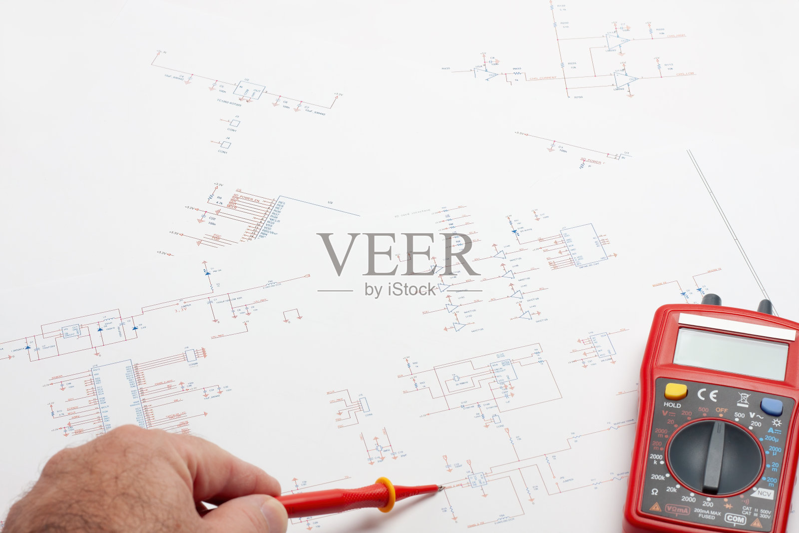 工程师的桌子上有电子蓝图和万用表。照片摄影图片