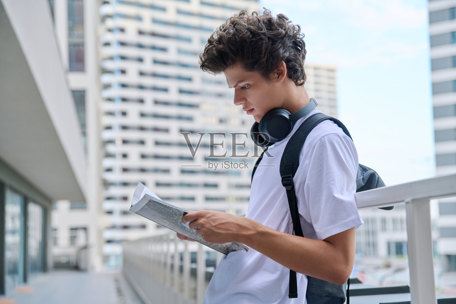 年轻帅气的大学生在户外读课本照片摄影图片