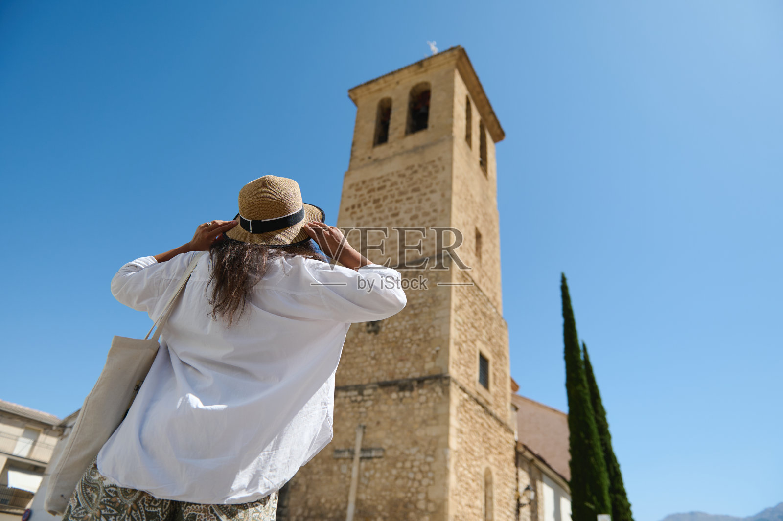 游客欣赏历史悠久的塔与清澈的蓝天照片摄影图片