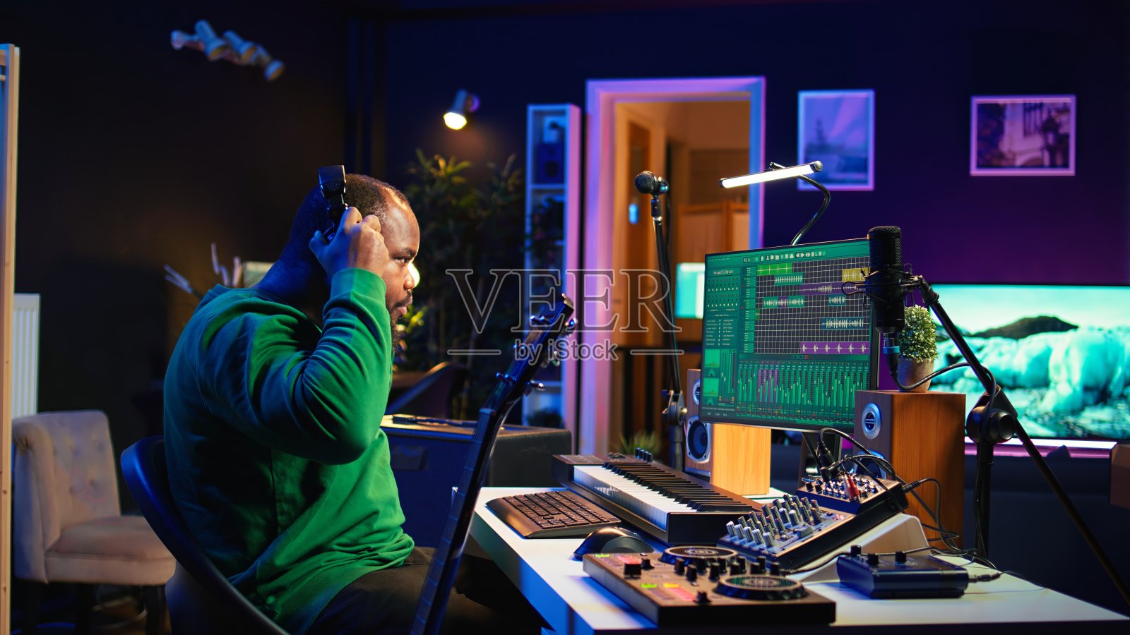 制作人创造一个轨道，在家庭工作室玩原声吉他照片摄影图片