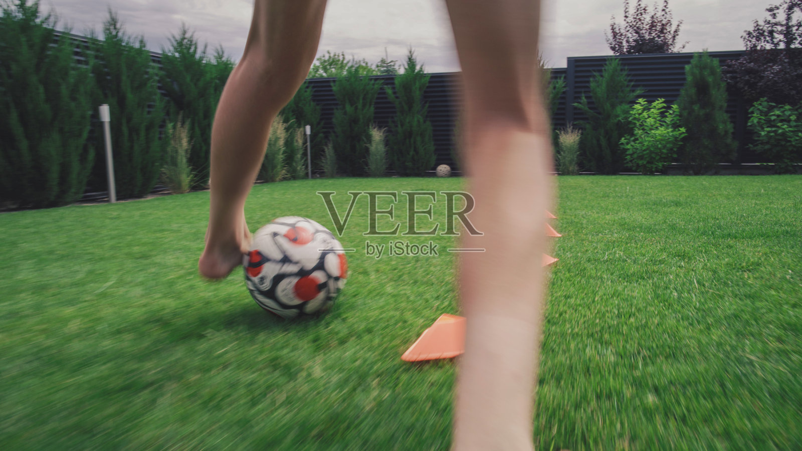 年轻的足球运动员在屋外的草坪上训练照片摄影图片
