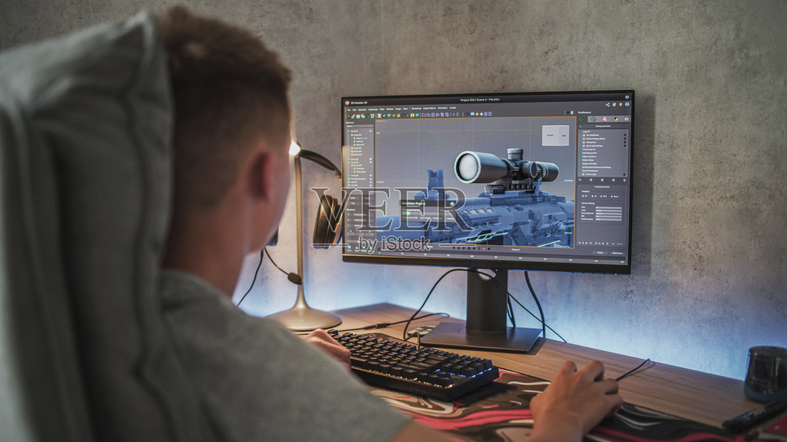 一个白人少年用电脑制作了狙击步枪的3D模型照片摄影图片