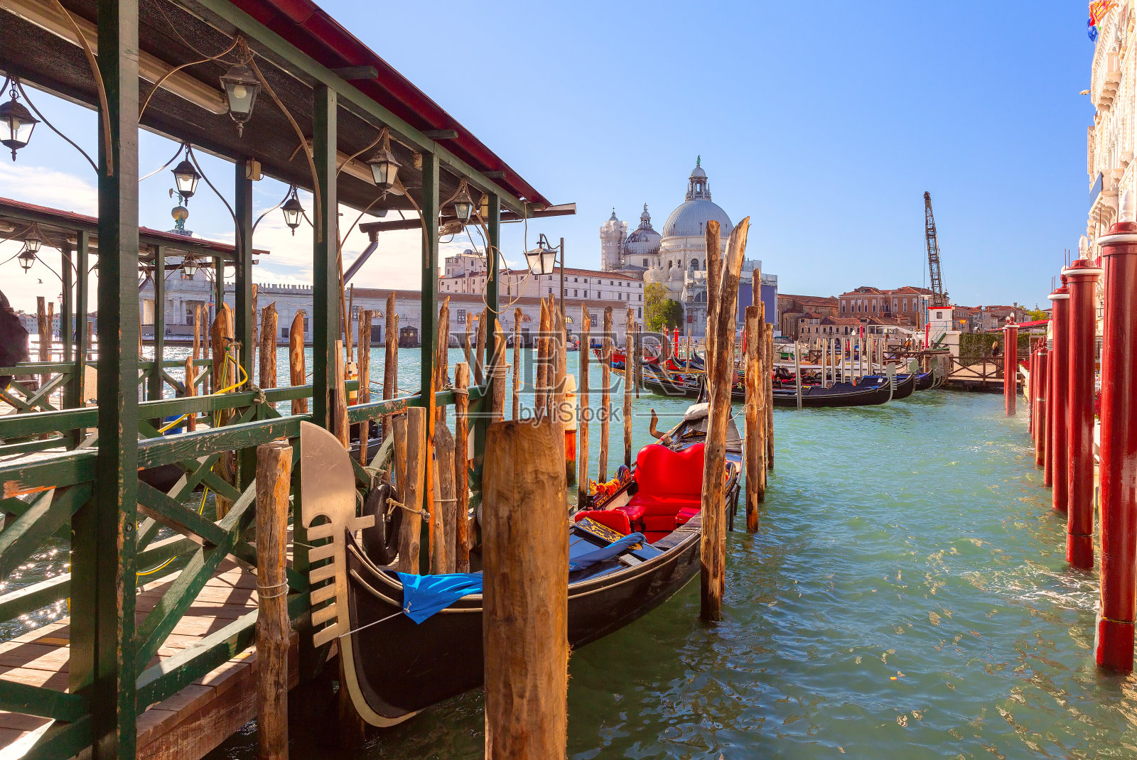 威尼斯大运河码头附近的黑色贡多拉。照片摄影图片