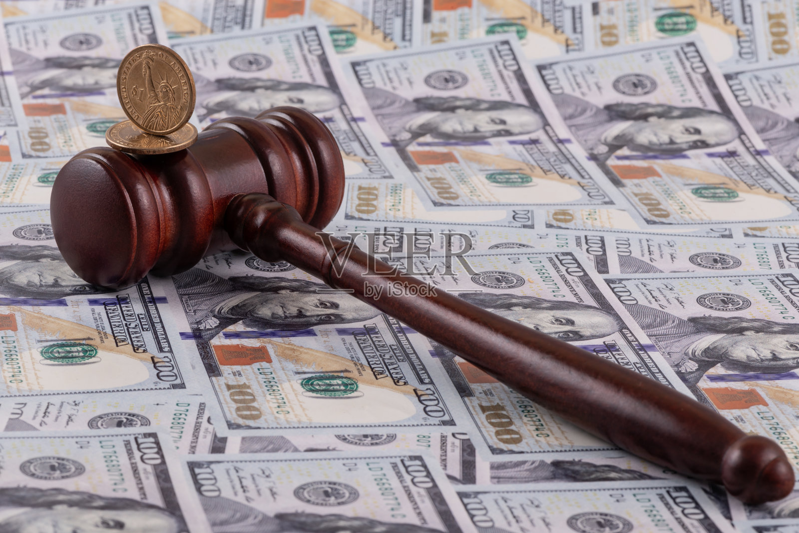 1美元硬币和法官的木槌，背景是100美元钞票照片摄影图片