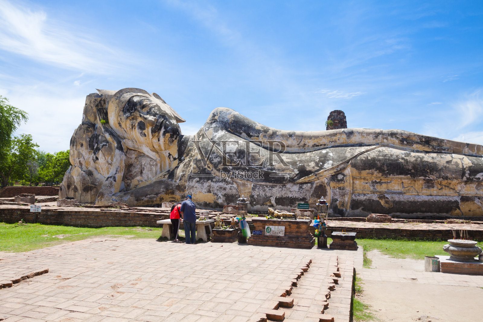 一对泰国夫妇正在参观巨大的卧佛雕像照片摄影图片
