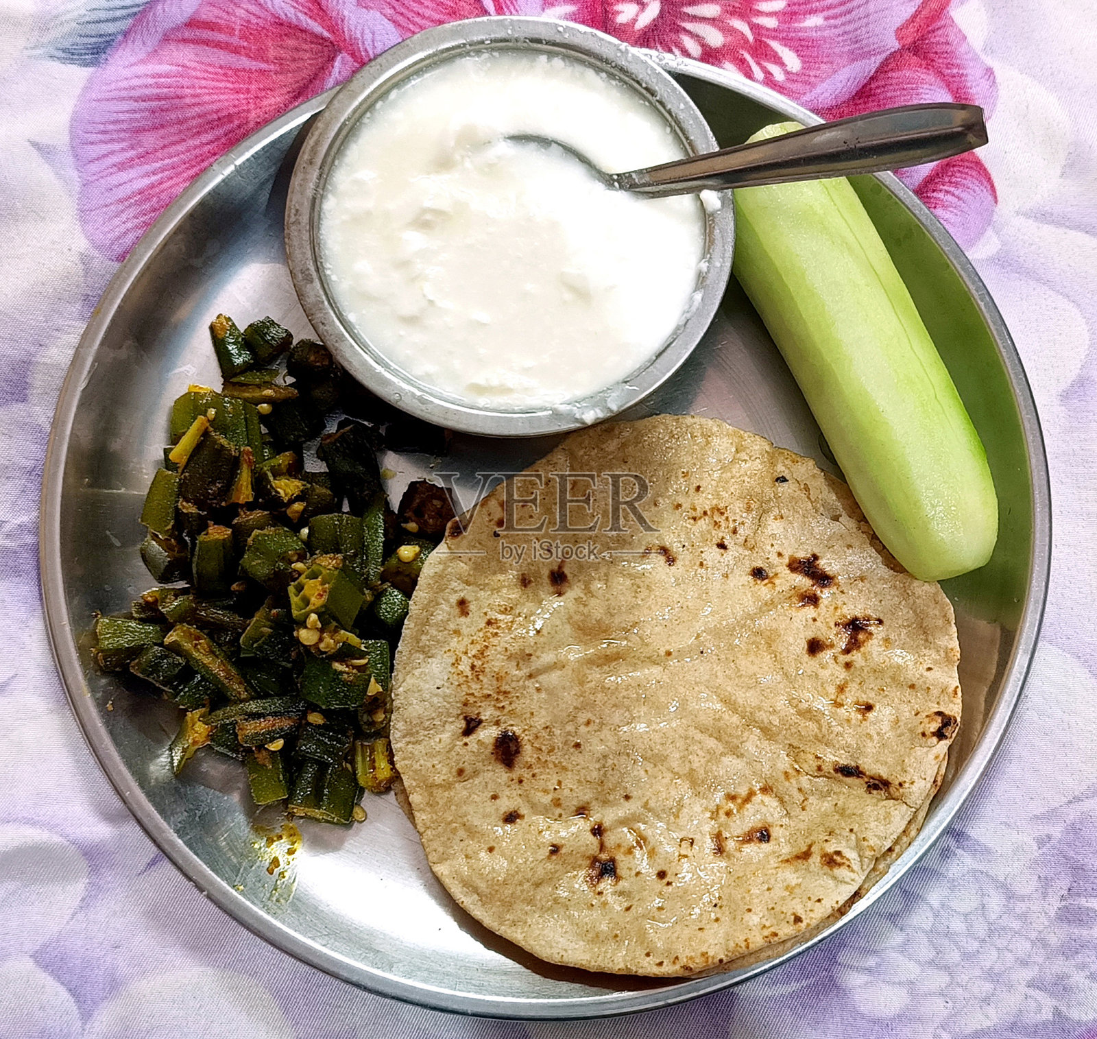 印度菜Bhindi或秋葵咖喱和Roti或chapati与凝乳在一个盘子里。有选择性的重点照片摄影图片