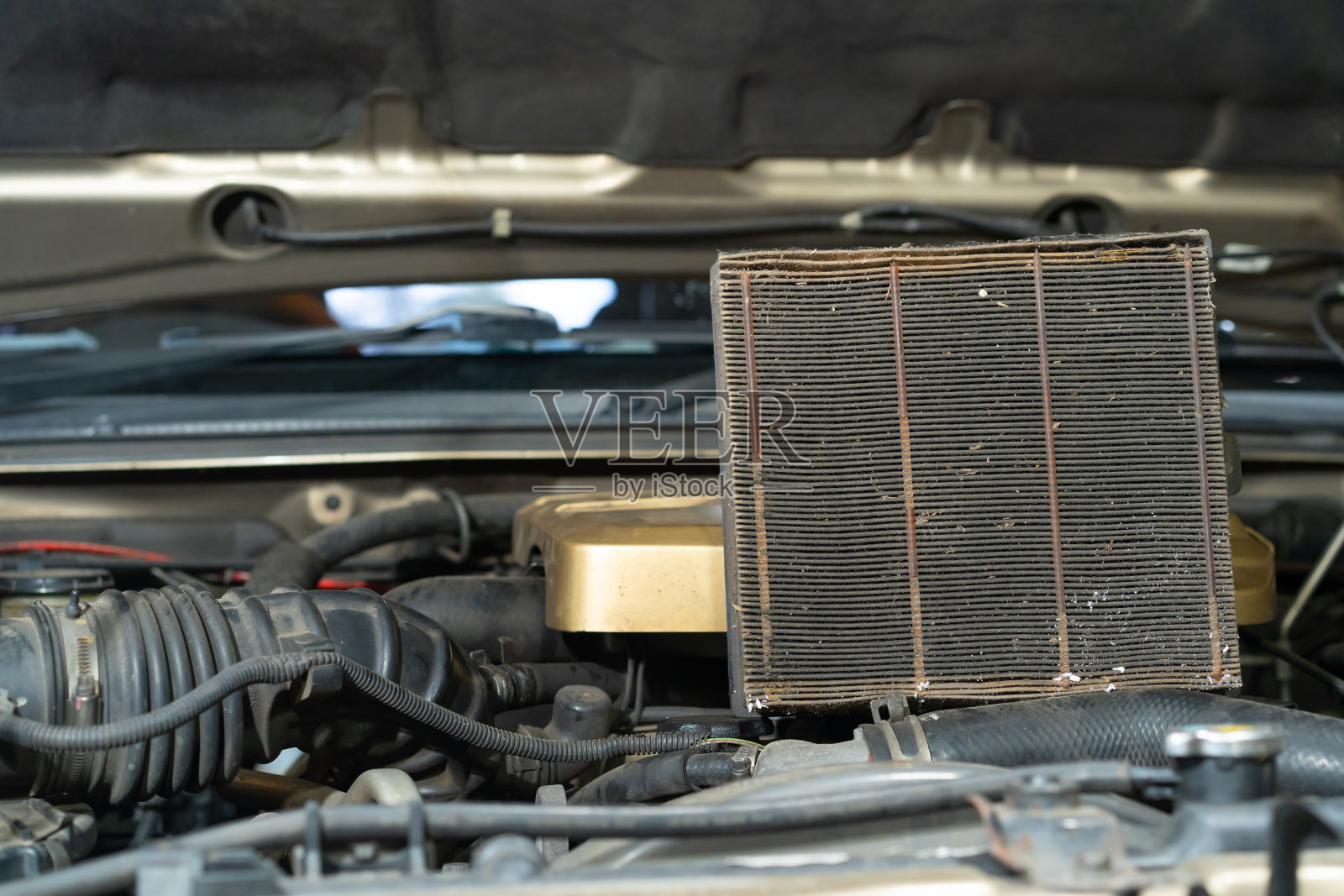 汽车引擎盖上的旧空气过滤器。照片摄影图片