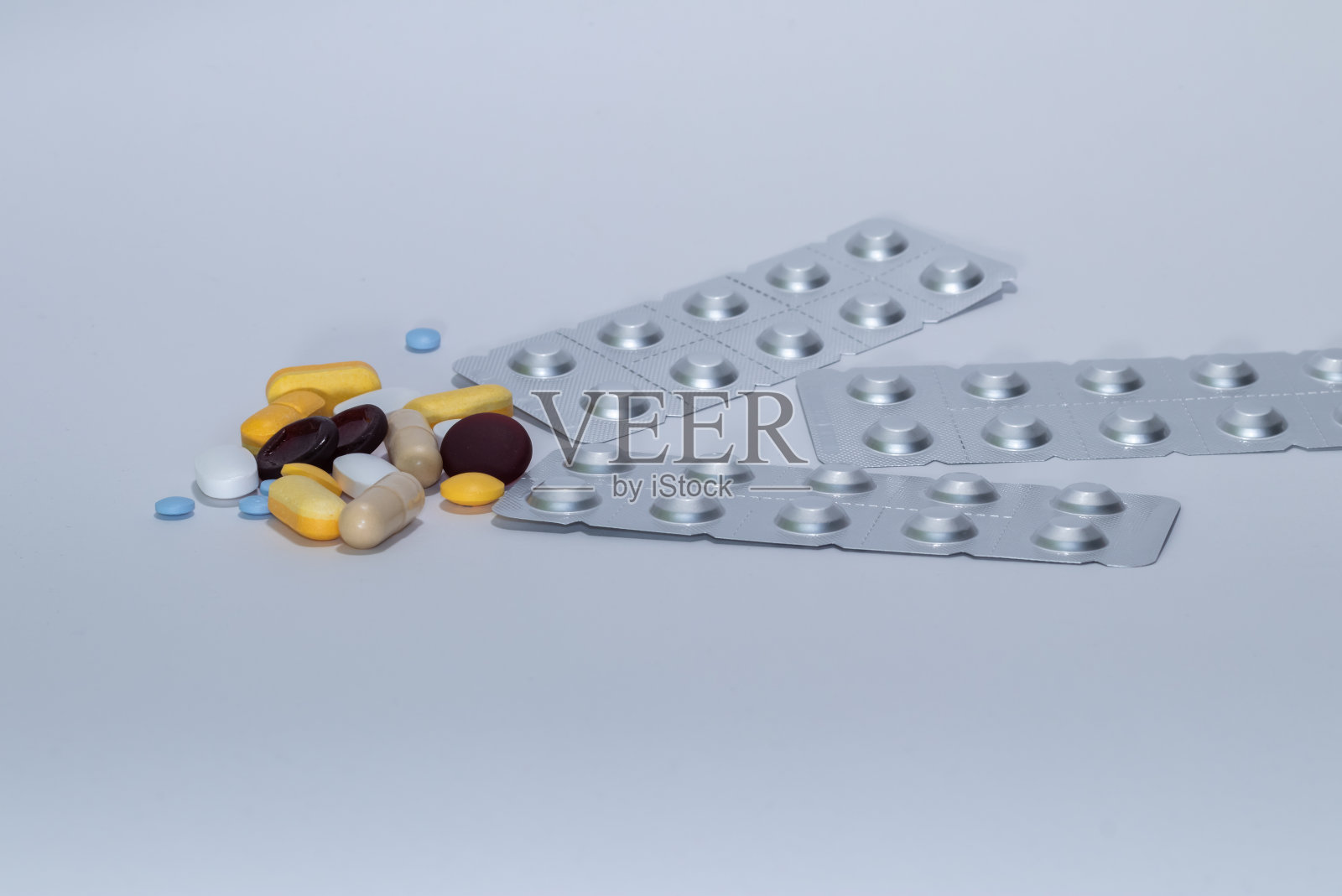 散落在白色上的各种彩色药丸照片摄影图片