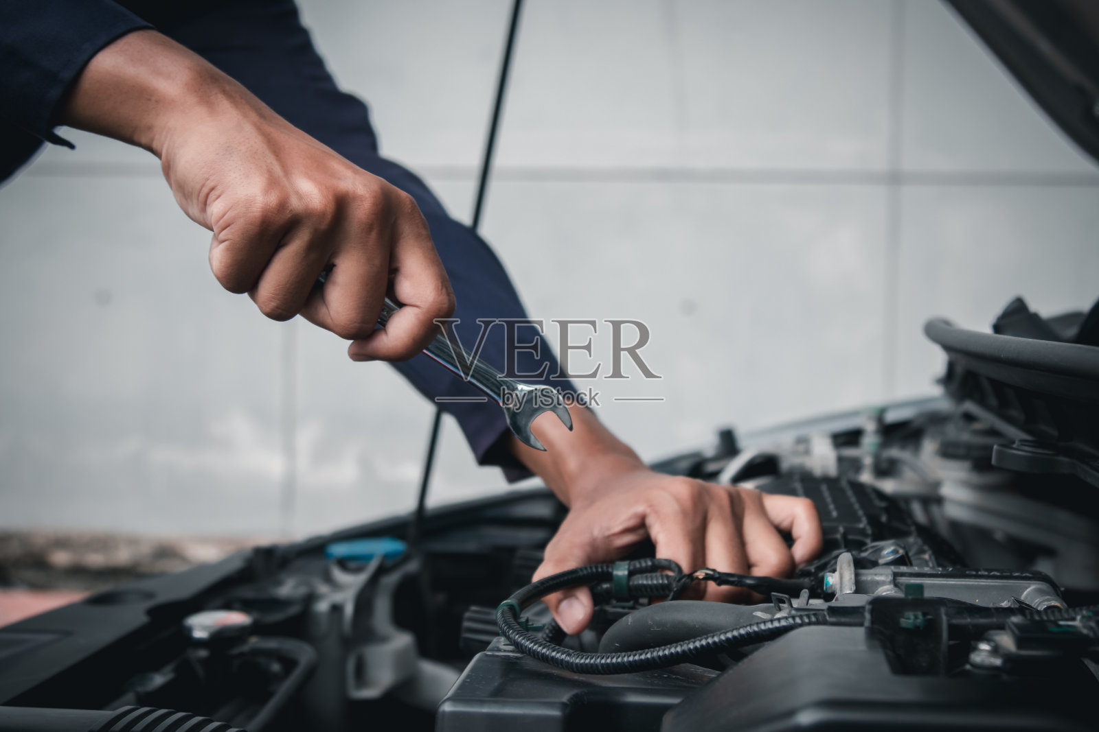 维修中心外的汽车发动机时使用扳手进行维修和服务。照片摄影图片