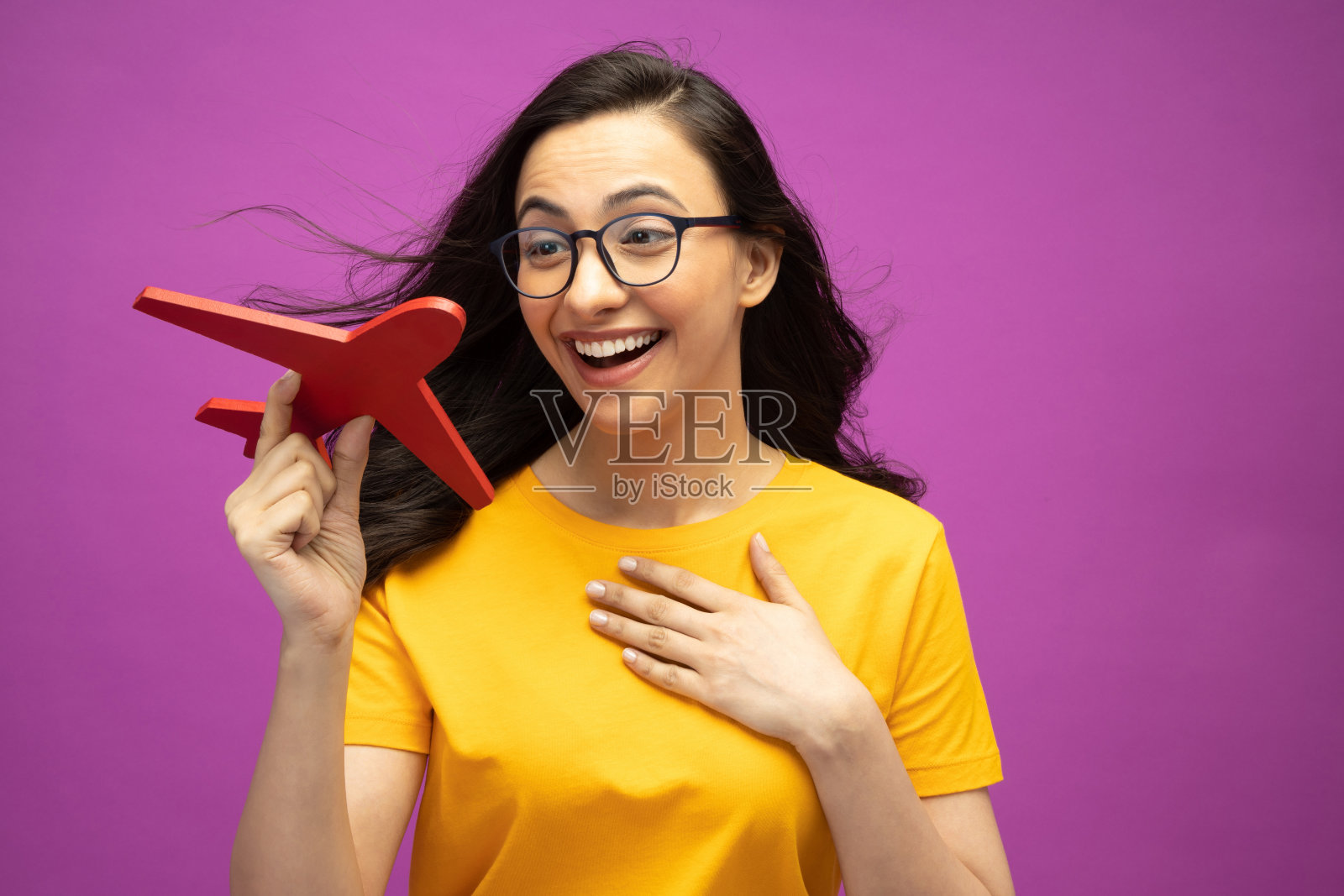 照片可爱漂亮的女孩穿着黄色t恤上孤立的紫色背景股票照片照片摄影图片