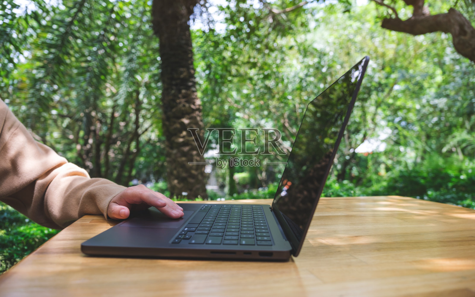 一名妇女在户外花园工作和触摸笔记本电脑触摸板的特写图像照片摄影图片