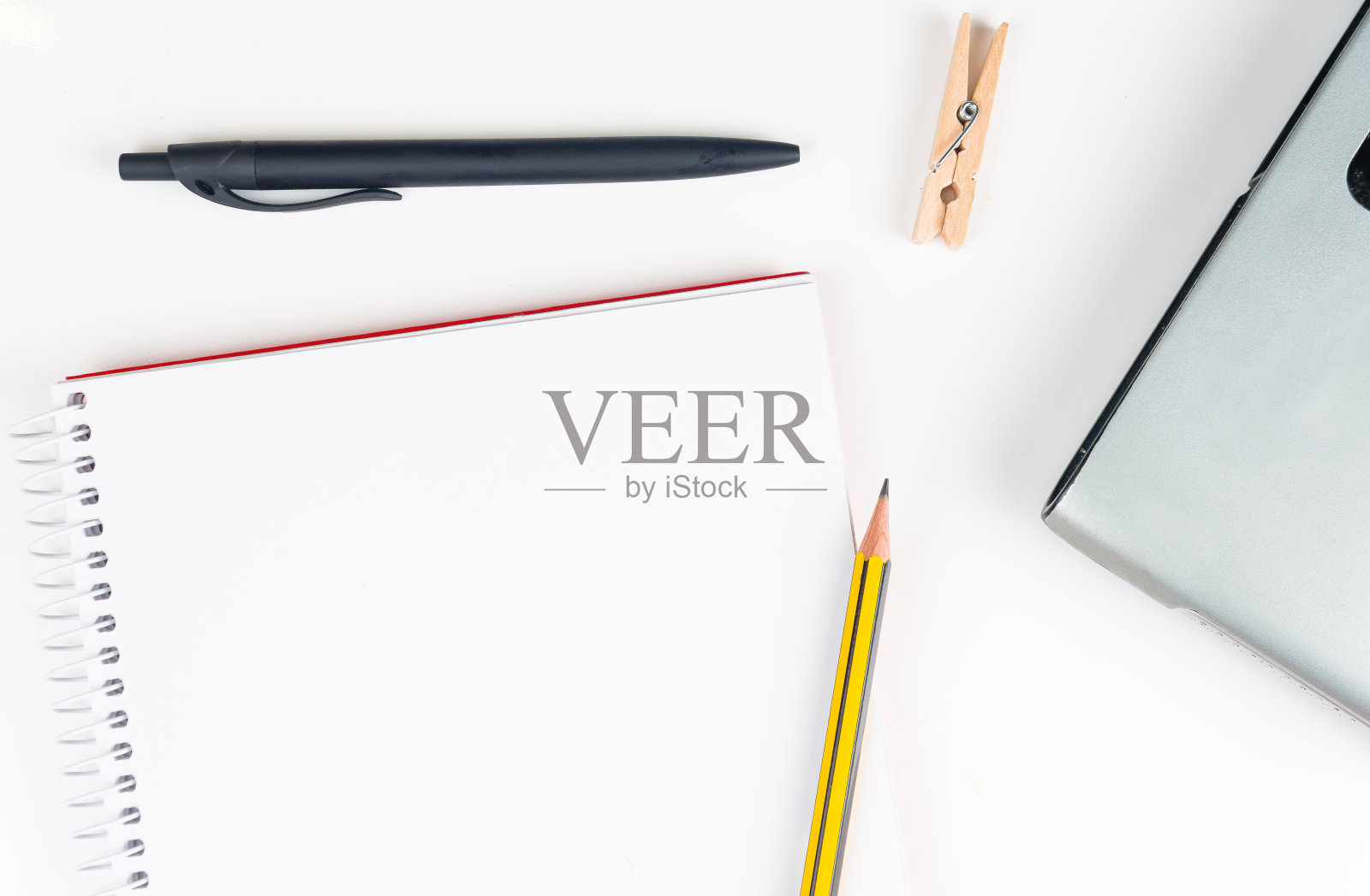 正上方的白色背景上的螺旋笔记本和办公用品照片摄影图片