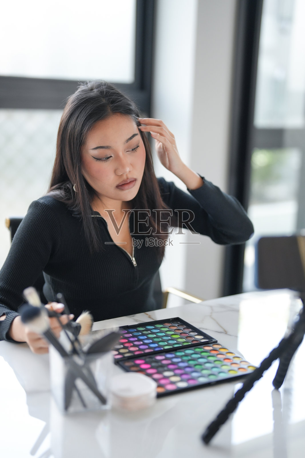 美容影响亚洲女孩推荐广告护肤。在她脸上涂化妆品霜照片摄影图片