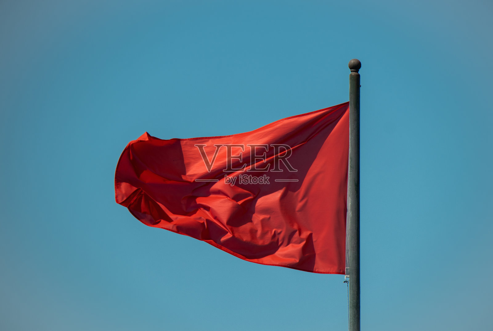 在蓝天背景上挥舞着红旗照片摄影图片