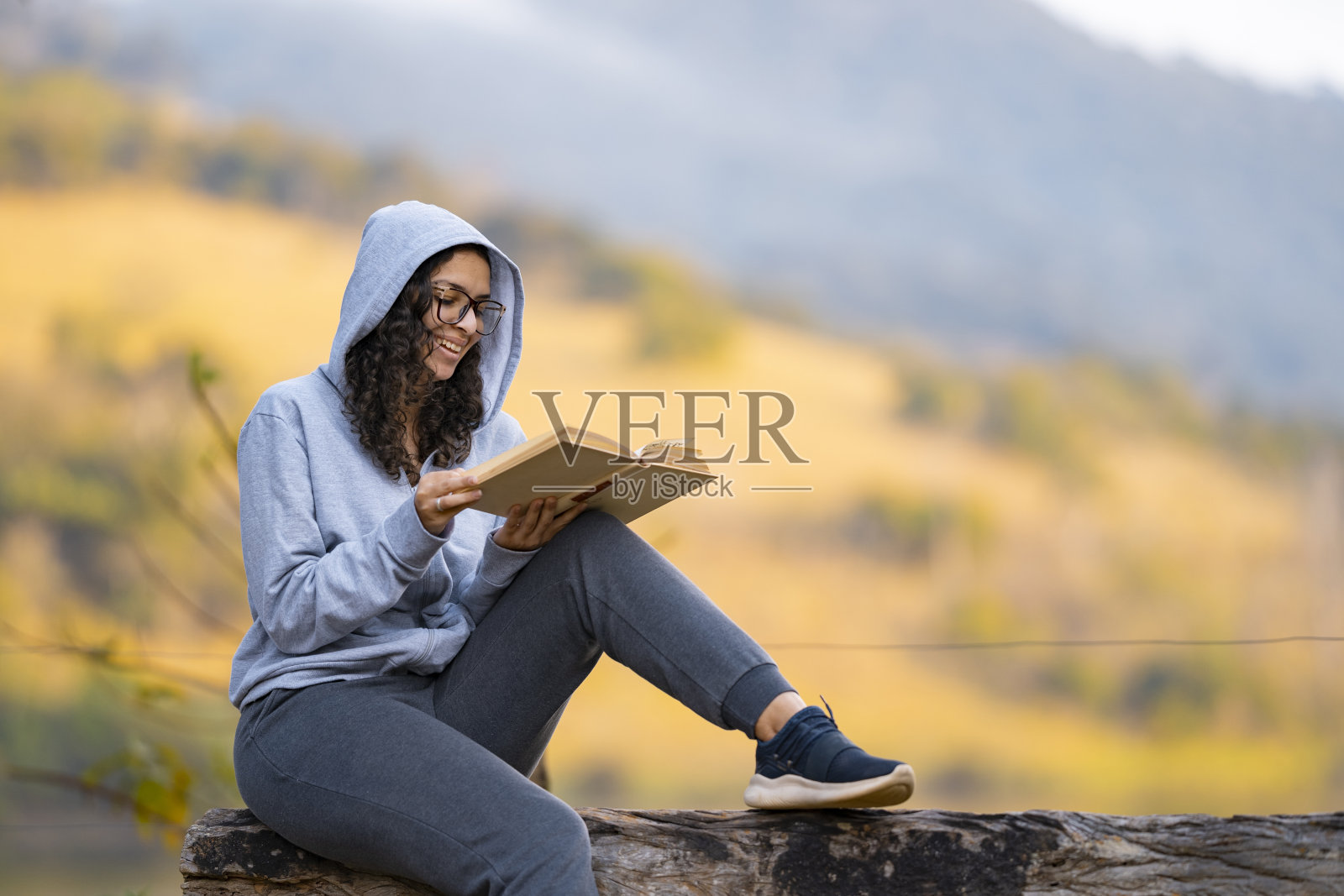 一个女人坐在大自然中看书照片摄影图片