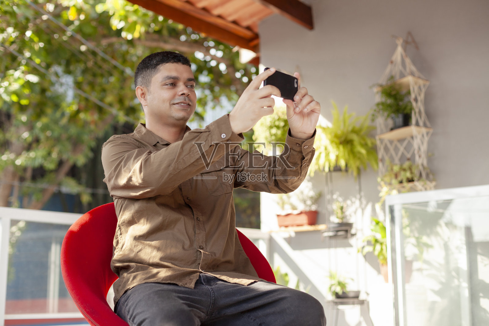手持手机进行视频通话的男子。照片摄影图片
