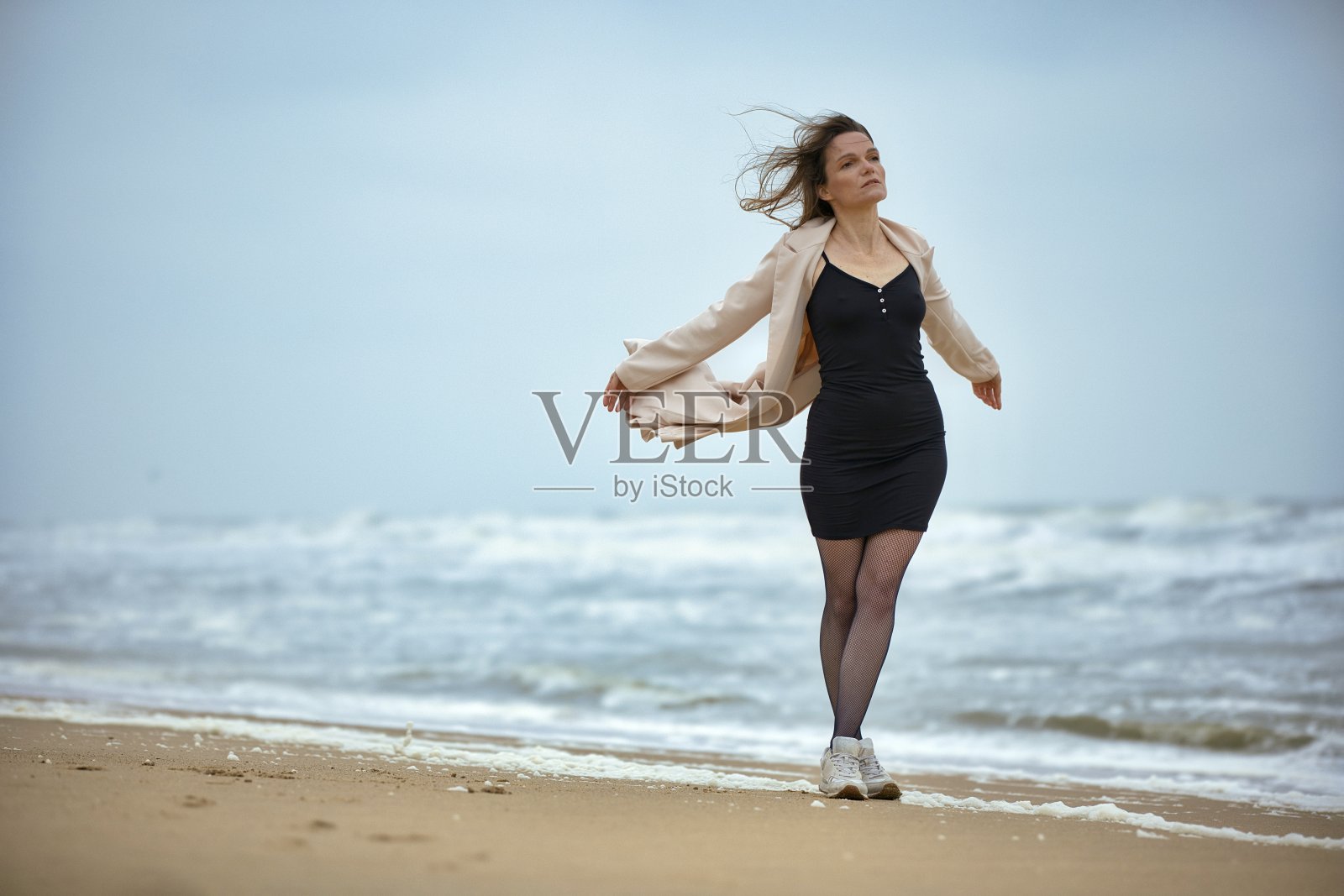 年轻女人独自在海边沙滩放松照片摄影图片