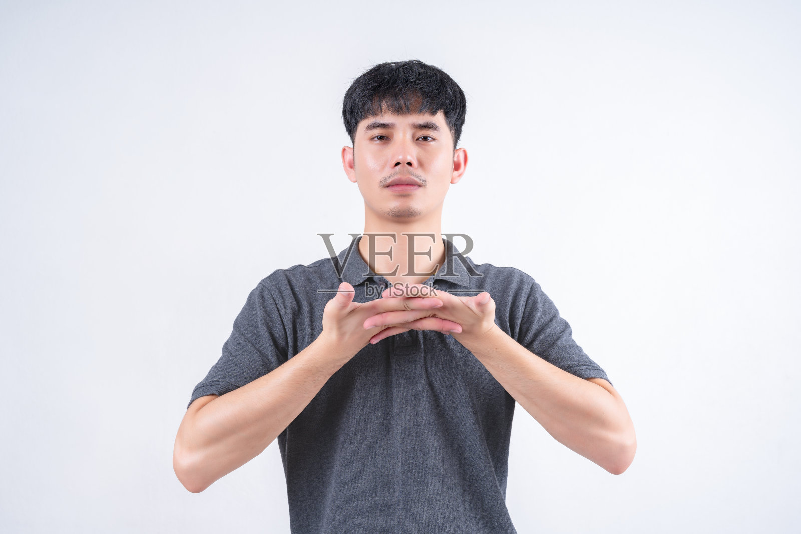 英俊的亚洲男人双手合十的肖像。白色背景上的团结和放松的概念。照片摄影图片