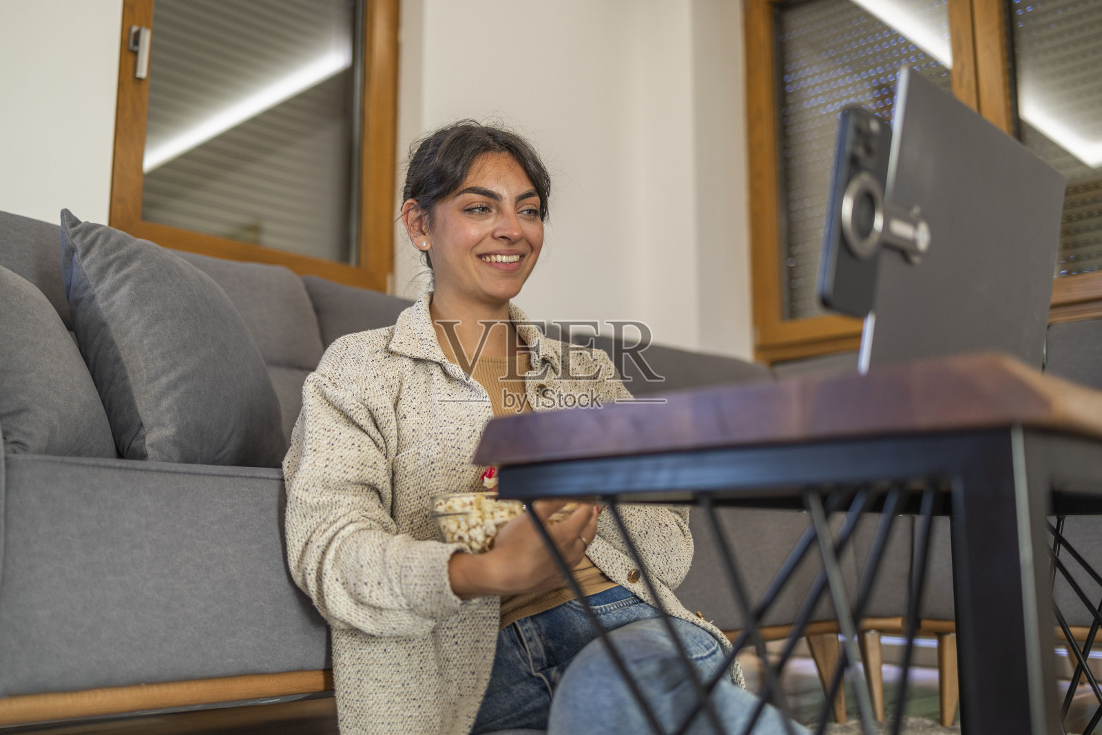 年轻女子用笔记本电脑躺在家里的床上看电影照片摄影图片