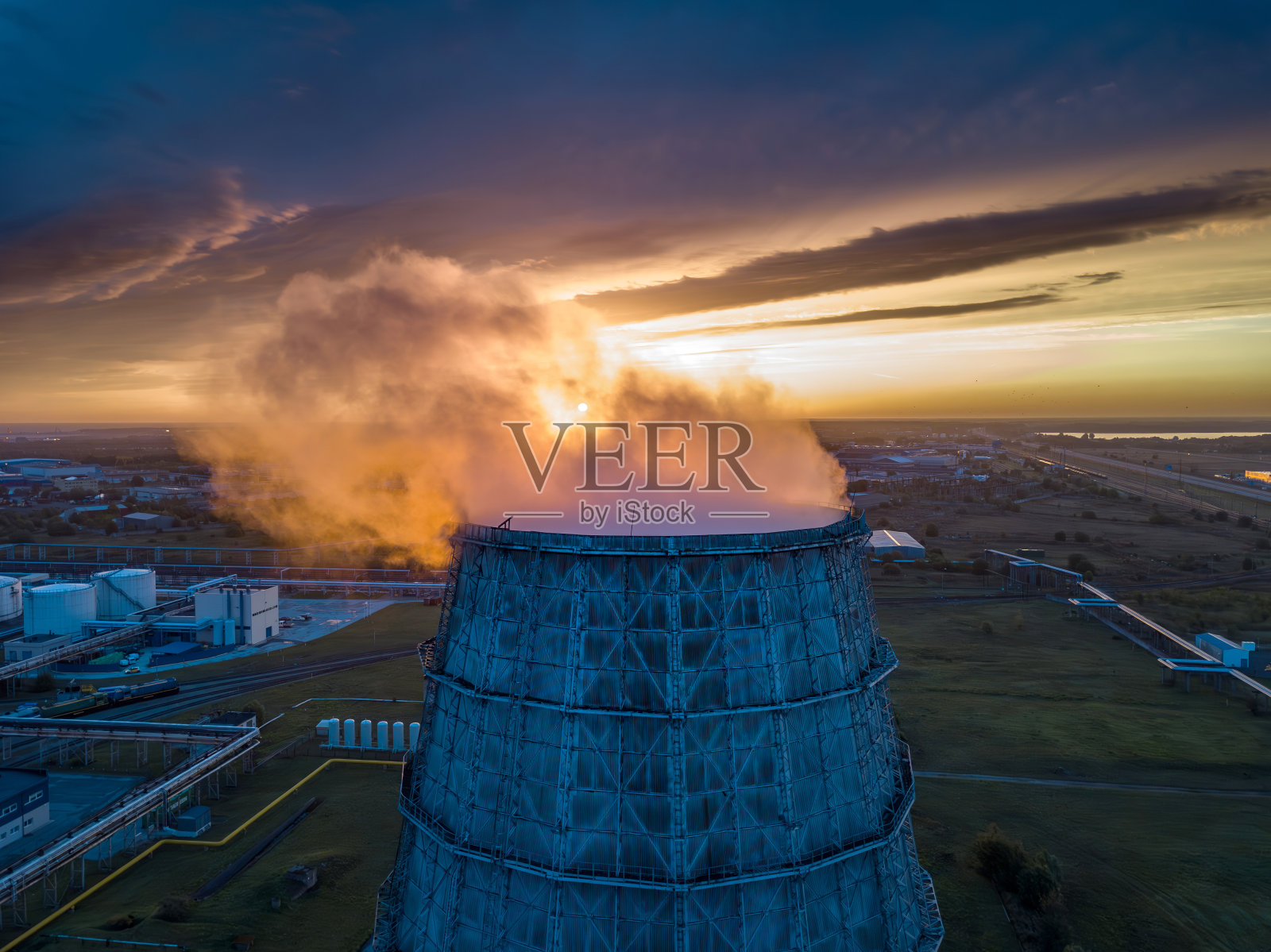 发电厂映衬着初升的太阳。照片摄影图片