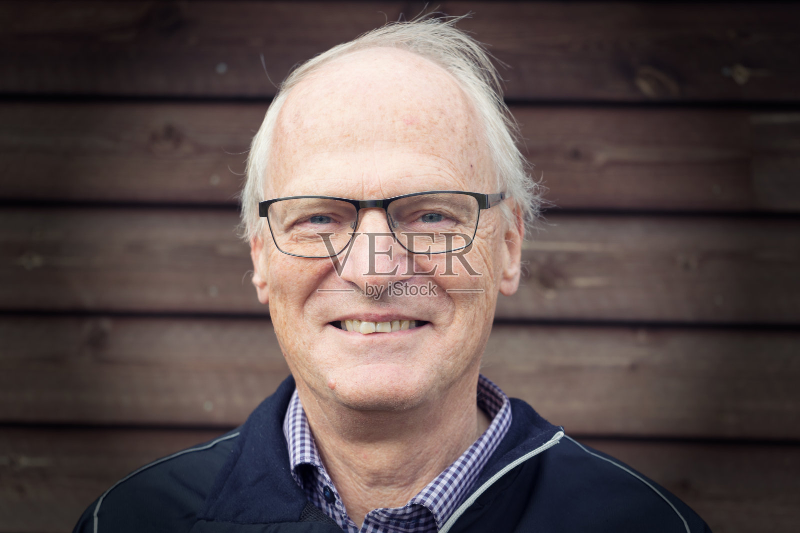 戴眼镜靠墙微笑的老人特写肖像照片摄影图片