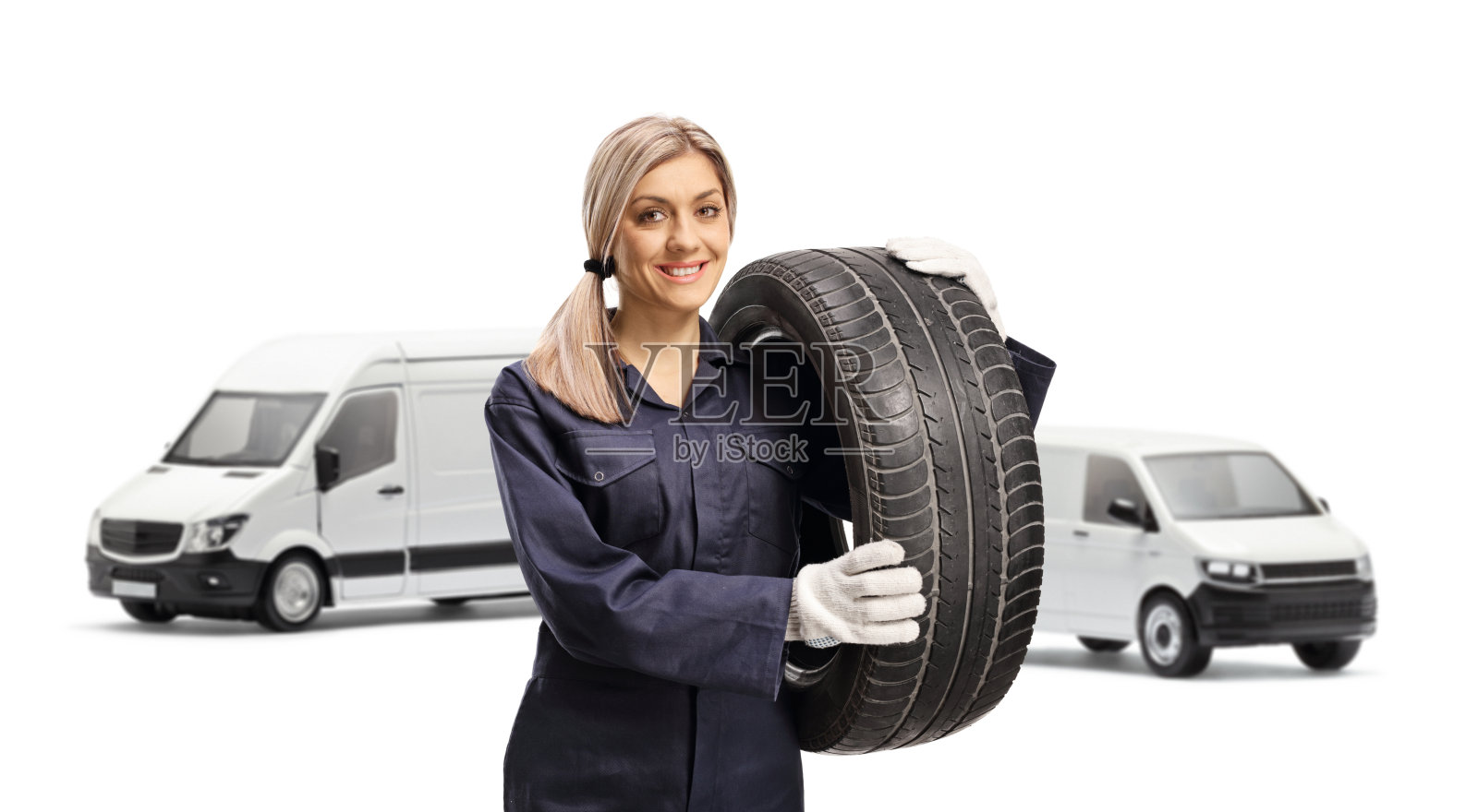 年轻的汽车修理工拿着一个货车轮胎照片摄影图片