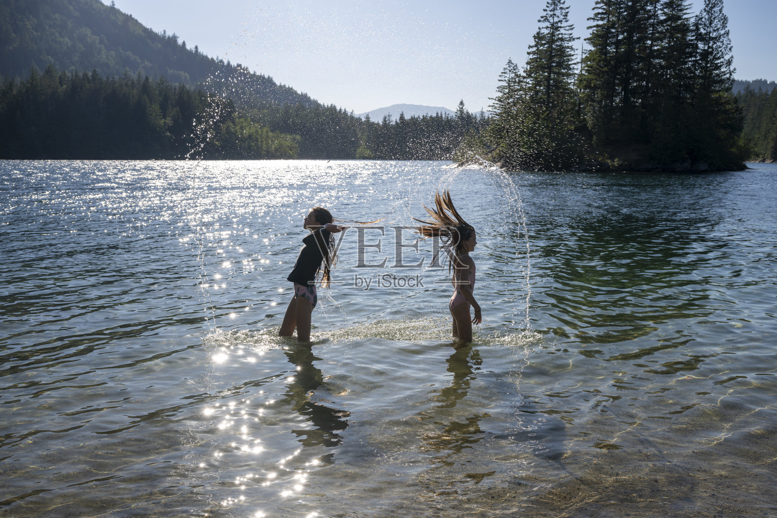 年轻女孩在湖里玩照片摄影图片