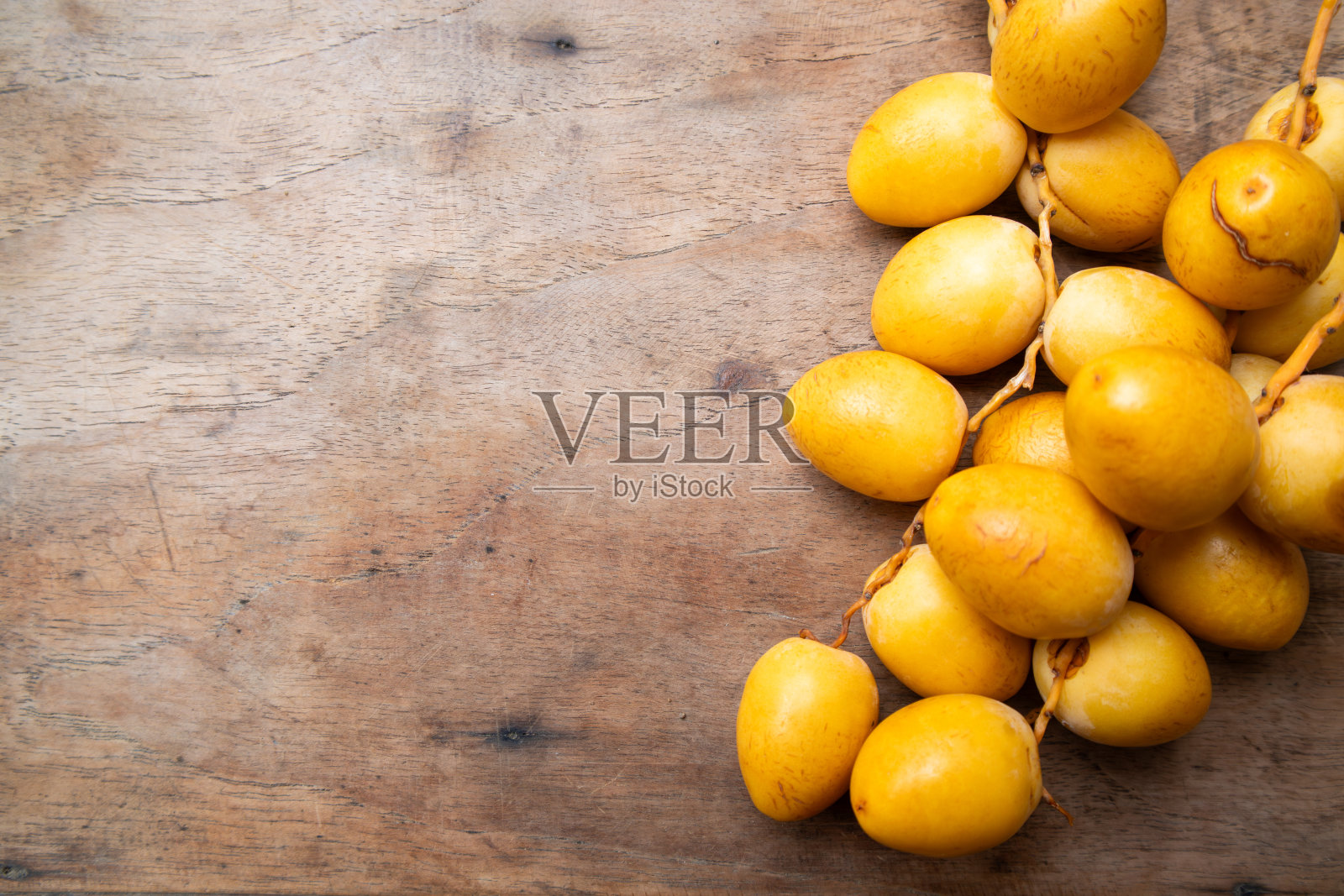 木桌上带有自由空间的美味黄色水果椰枣背景照片摄影图片