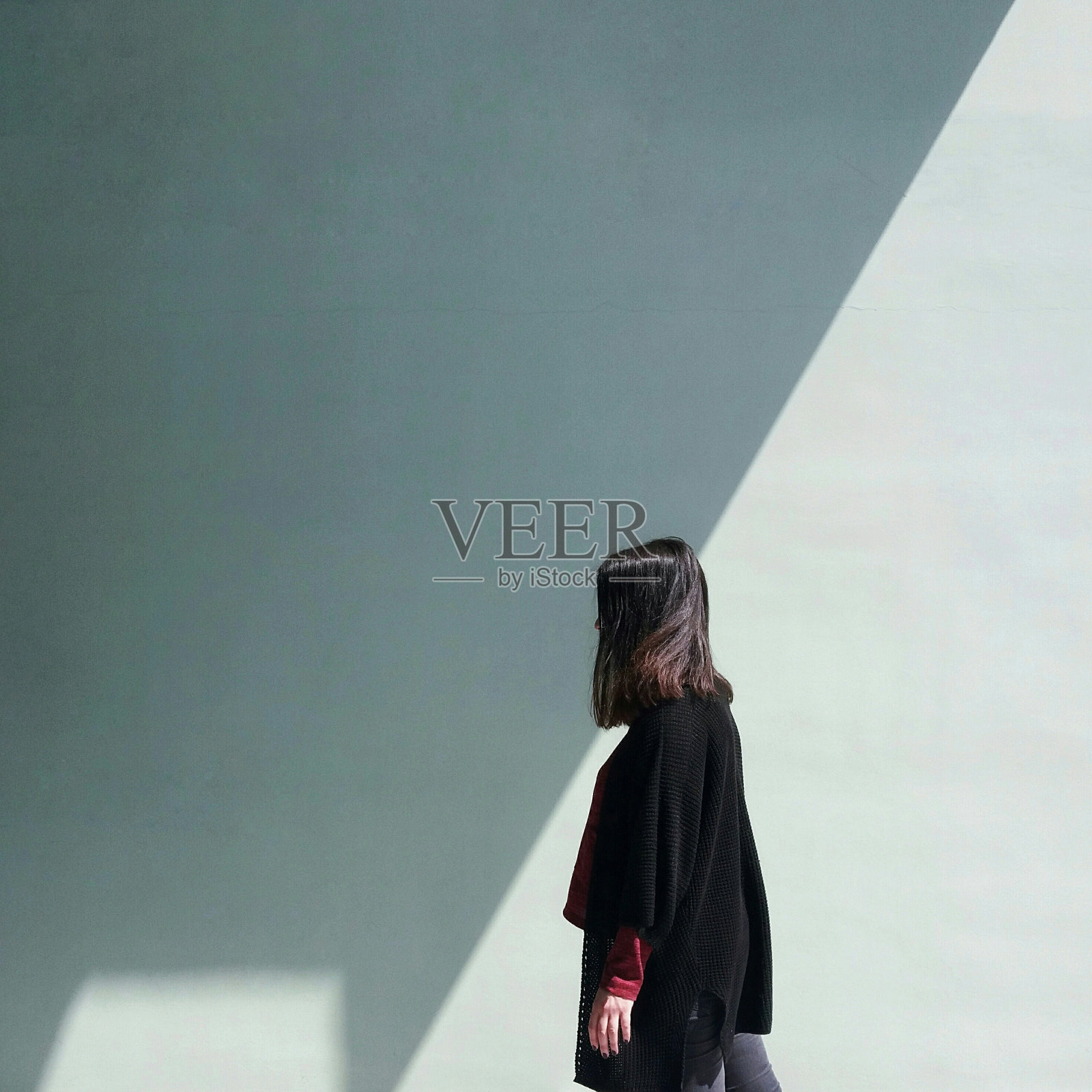 靠墙站着的女人的侧视图照片摄影图片