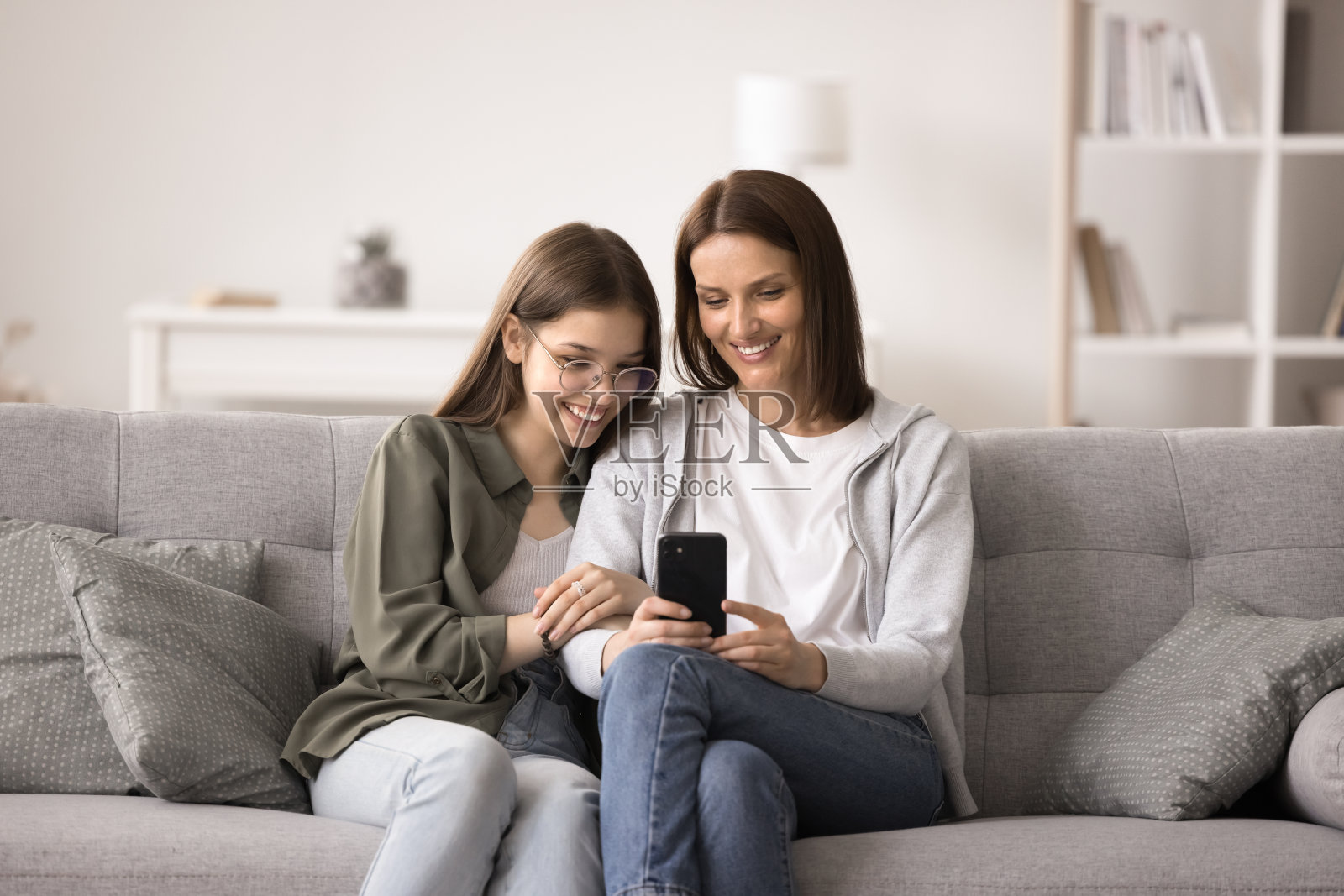 和妈妈在社交网络上看视频的女孩用智能手机照片摄影图片