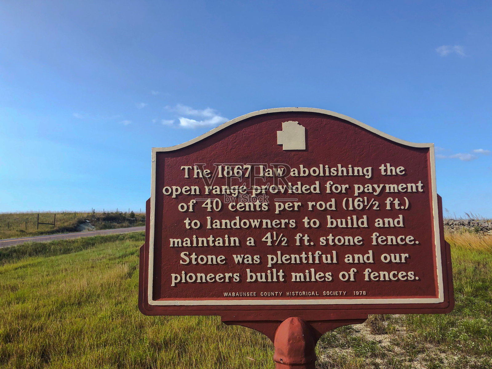 堪萨斯州瓦本西县晴朗蓝天下的草地上的历史标志照片摄影图片