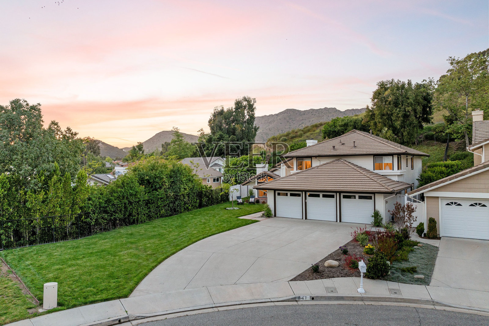 郊区社区与现代的房子和风景秀丽的山背景在日落。照片摄影图片