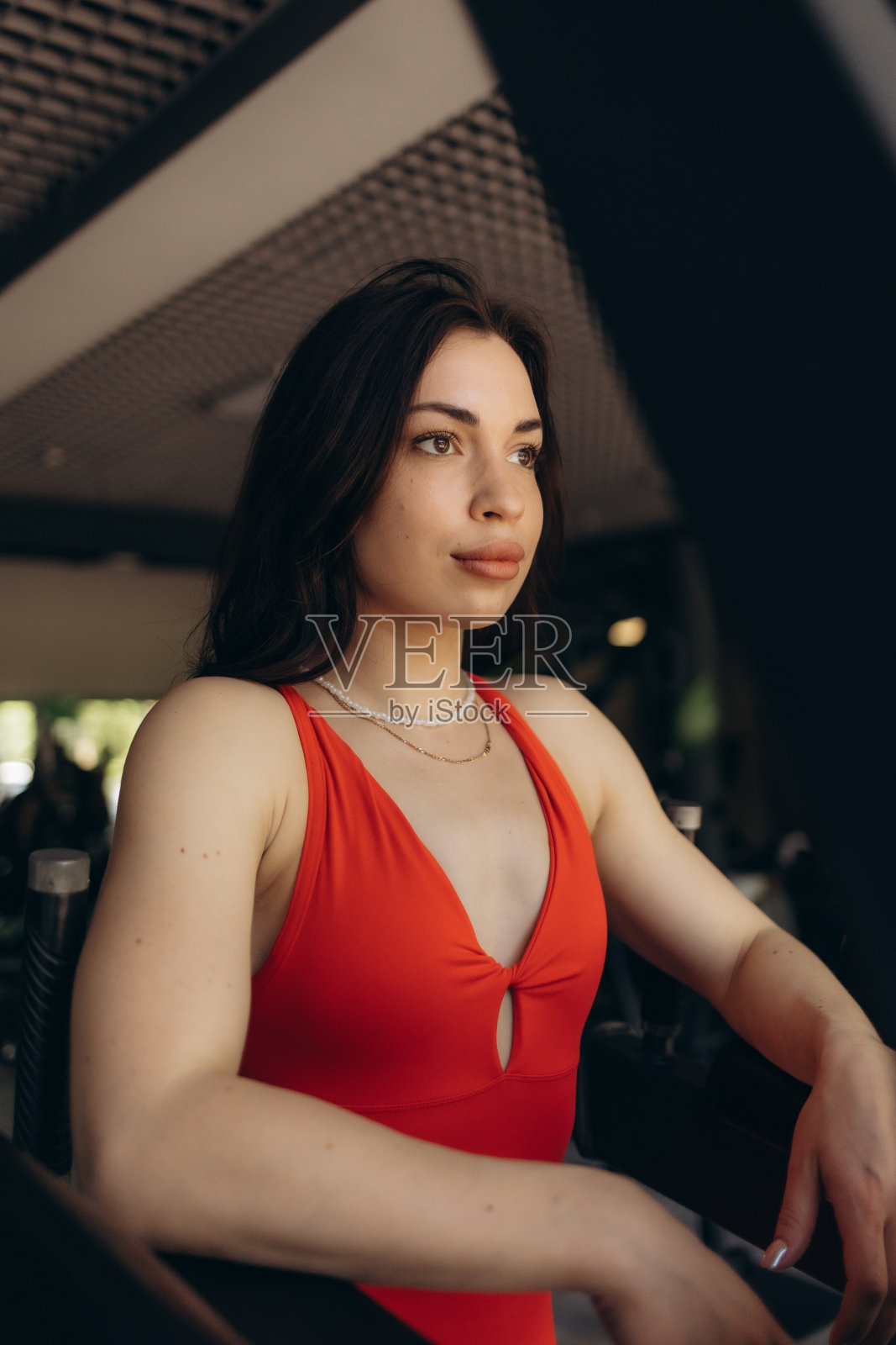 身穿运动服的年轻女性在健身房弯腰，双手放在膝盖上。健身女性在剧烈的综合健身锻炼后看起来很累。照片摄影图片