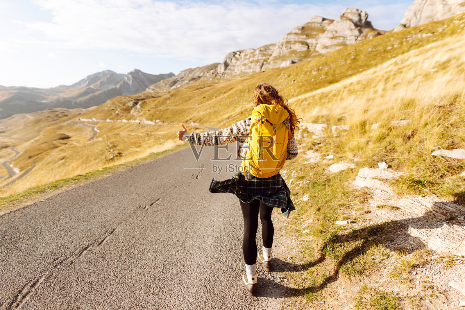 搭便车的女旅行者试图在山路上停车。照片摄影图片