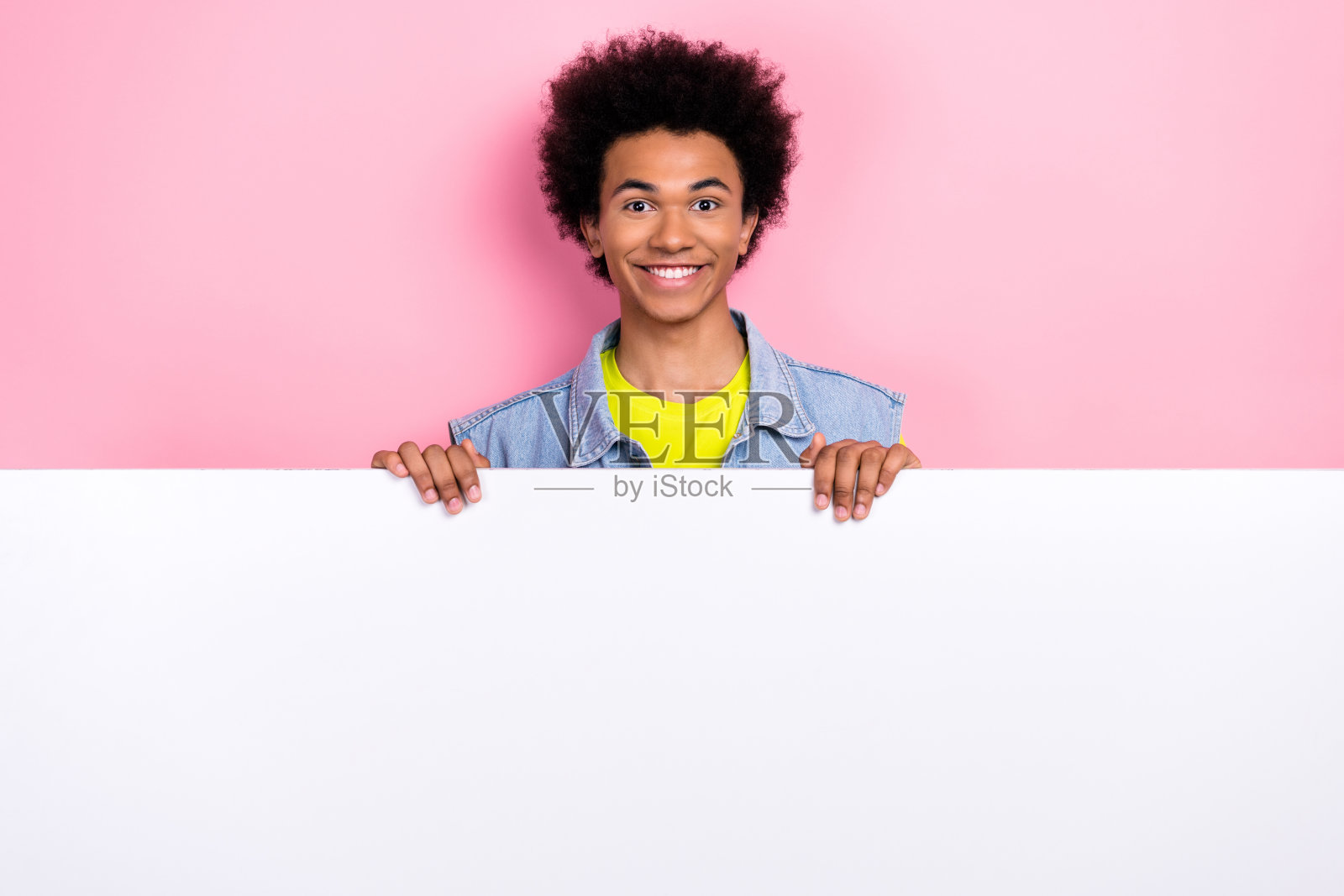 有趣的积极的男人穿着时尚的衣服的照片，展示了新产品空白的空间特别优惠孤立在粉红色的背景照片摄影图片