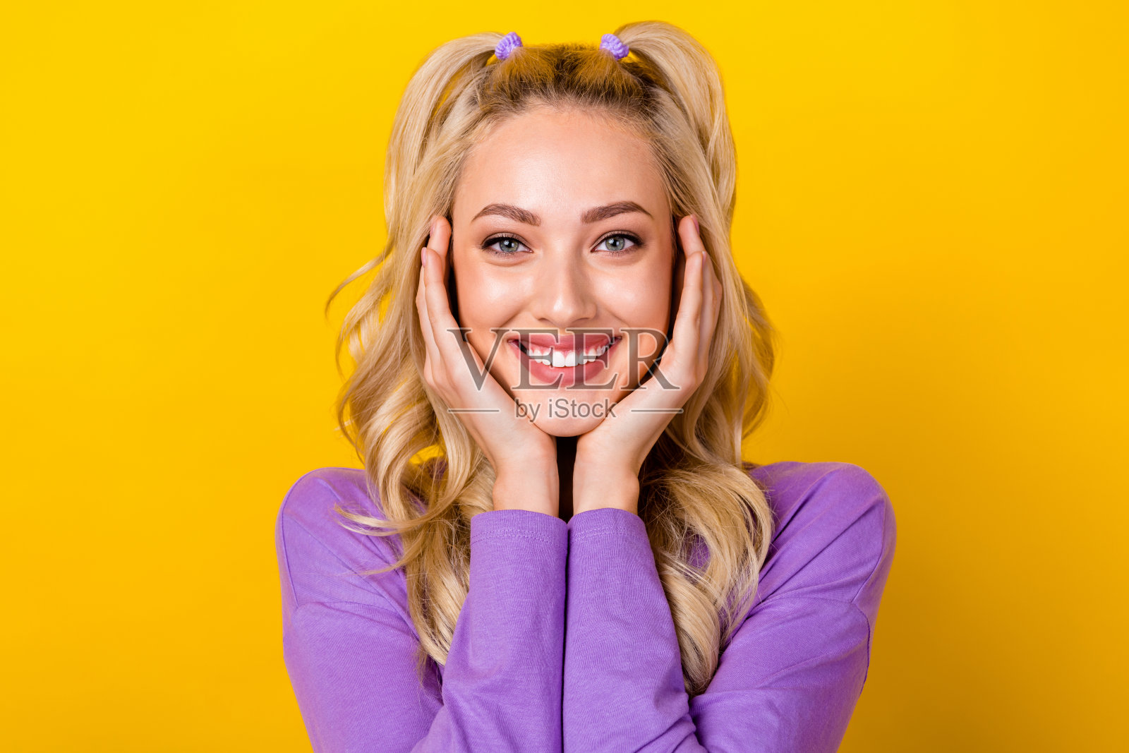 照片中梦幻可爱的女士穿着紫色衬衫微笑的手臂脸颊孤立的黄色背景照片摄影图片