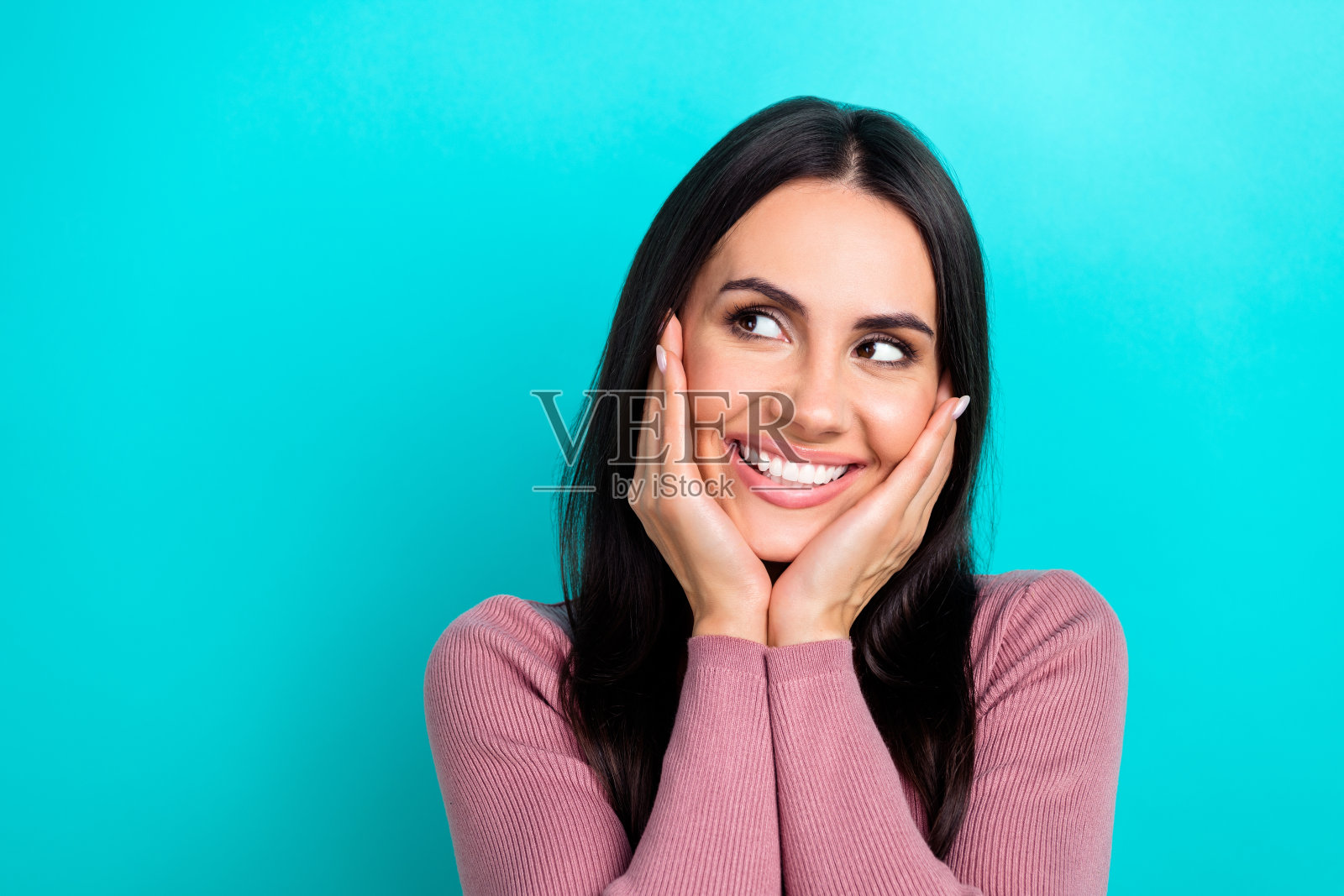 梦幻般的年轻女孩的特写照片，触摸脸颊，黑发，看模拟广告购物戴森电子隔离在海蓝宝石的颜色背景照片摄影图片
