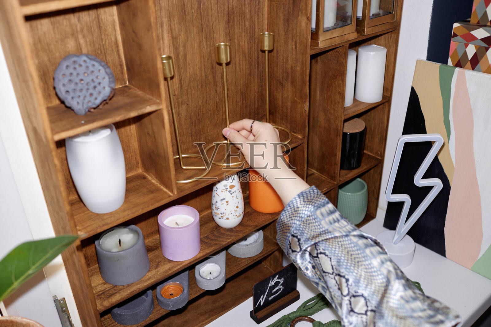 女性手从旧货店的展示柜中取出烛台照片摄影图片