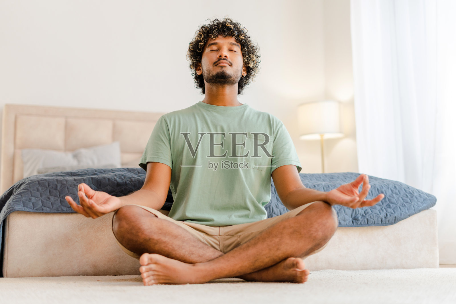 一名印度男子在家中以莲花姿势练习冥想照片摄影图片