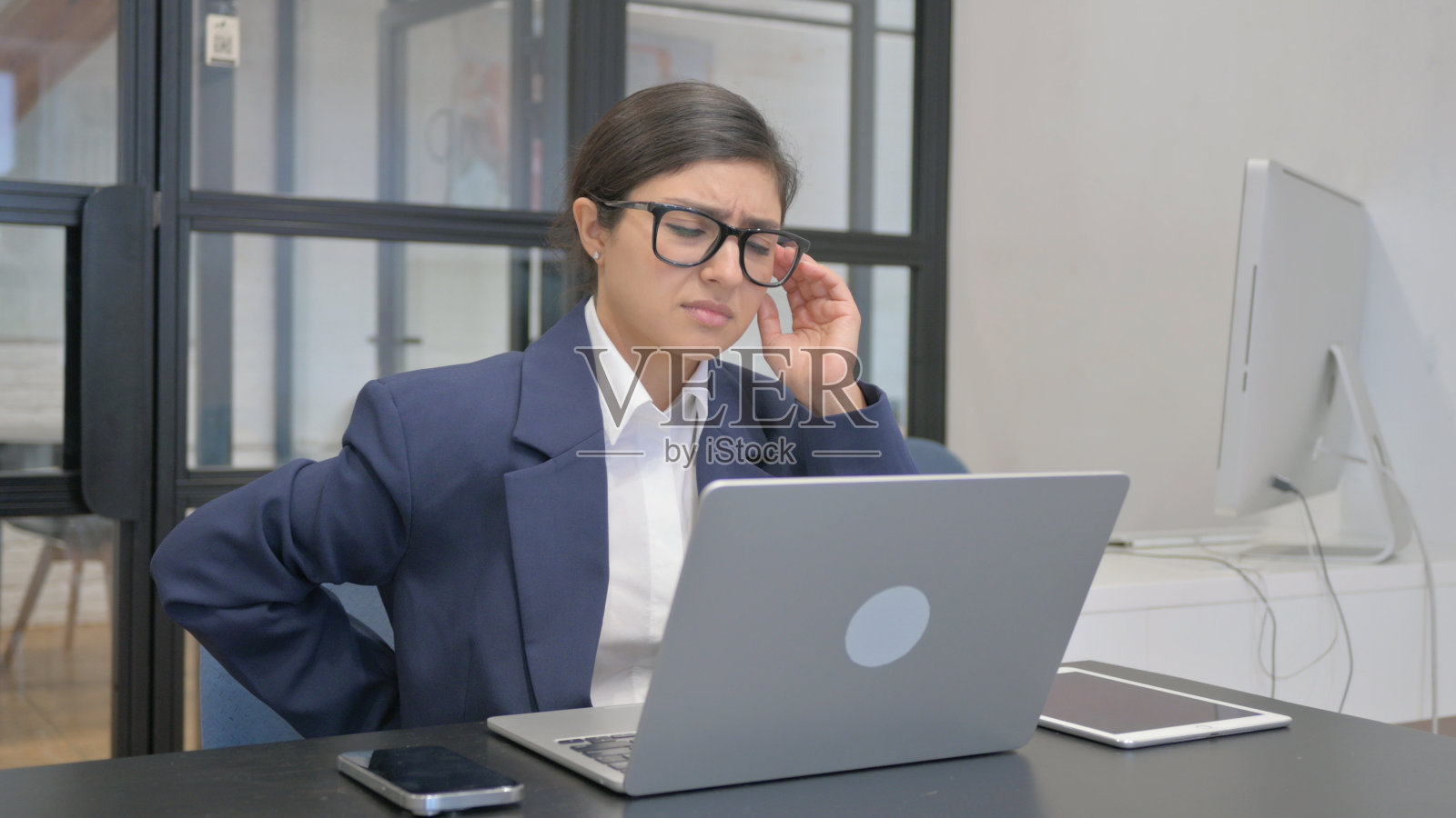 印度女商人在办公室背痛照片摄影图片