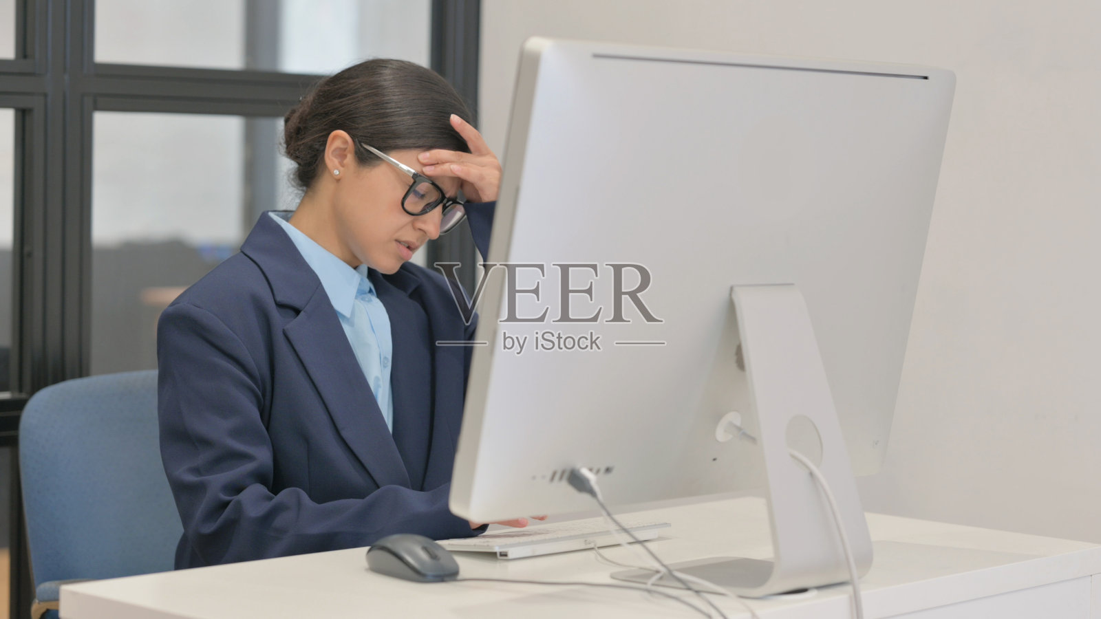 患有偏头痛的年轻印度女商人正在桌面上工作照片摄影图片