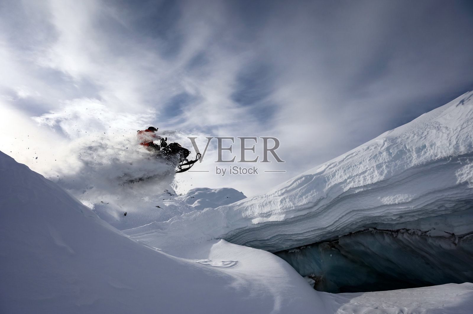 偏远地区的雪地摩托在冰洞前跳跃照片摄影图片