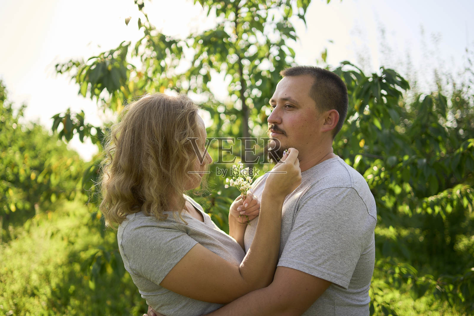 妻子把花编织在丈夫的胡子上照片摄影图片